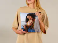 Fotokissen 30x30 mit Freundschaftsfoto Fotokissen 30x30 wird in einer Hand gehalten. Es ist mit einem Foto von zwei Frauen drauf gestaltet.