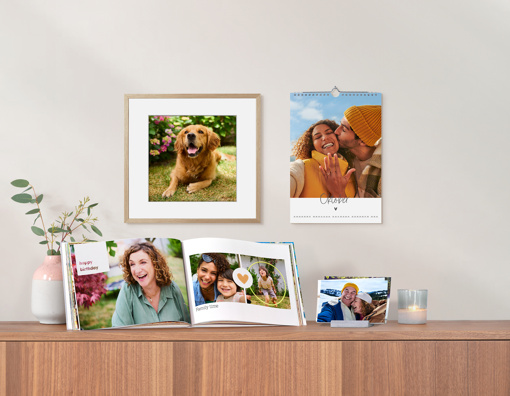 Livre photo, un tableau photo, un calendrier photo et des tirages photo posés sur une commode et accroché à un mur