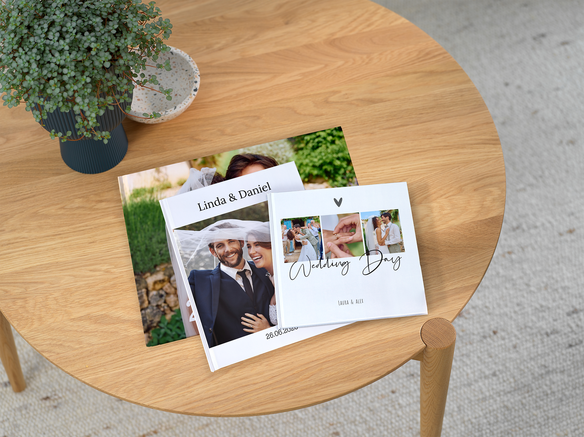 Auf einem Tisch liegen drei Hochzeitsfotobücher mit unterschiedlichen Designs.