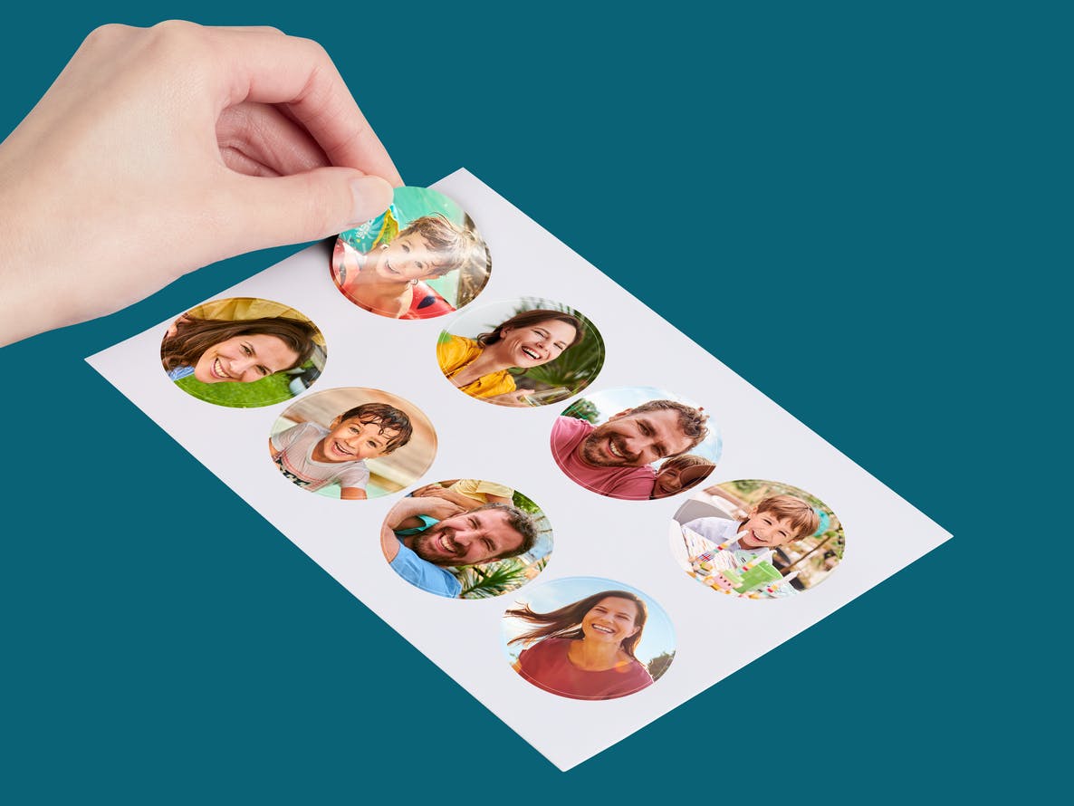 Runda fotoklistermärken på glansigt fotopapper med bilder av en familj
