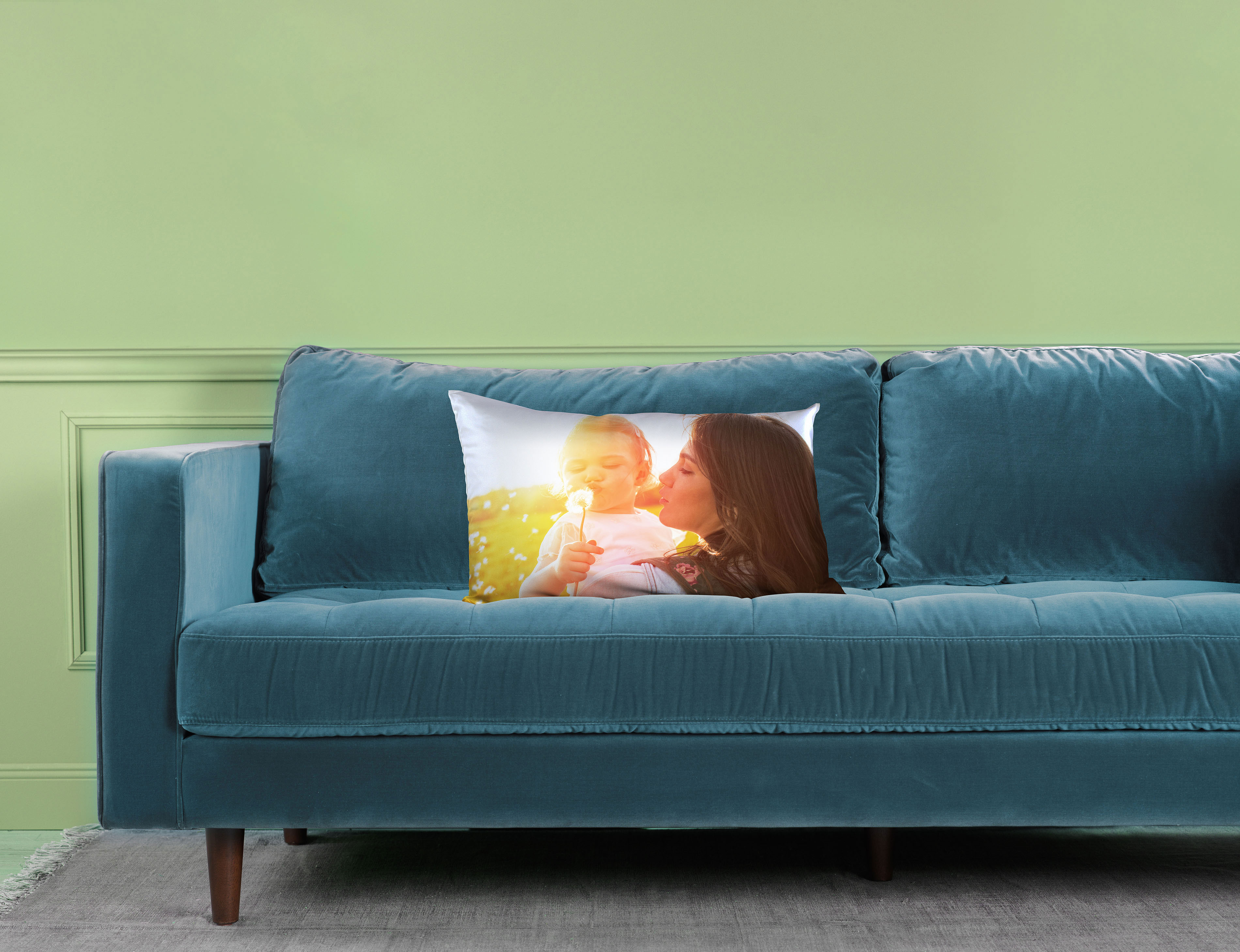 Fotokissen 80x40 cm mit Mutter-Kind-Motiv auf einem Sofa.