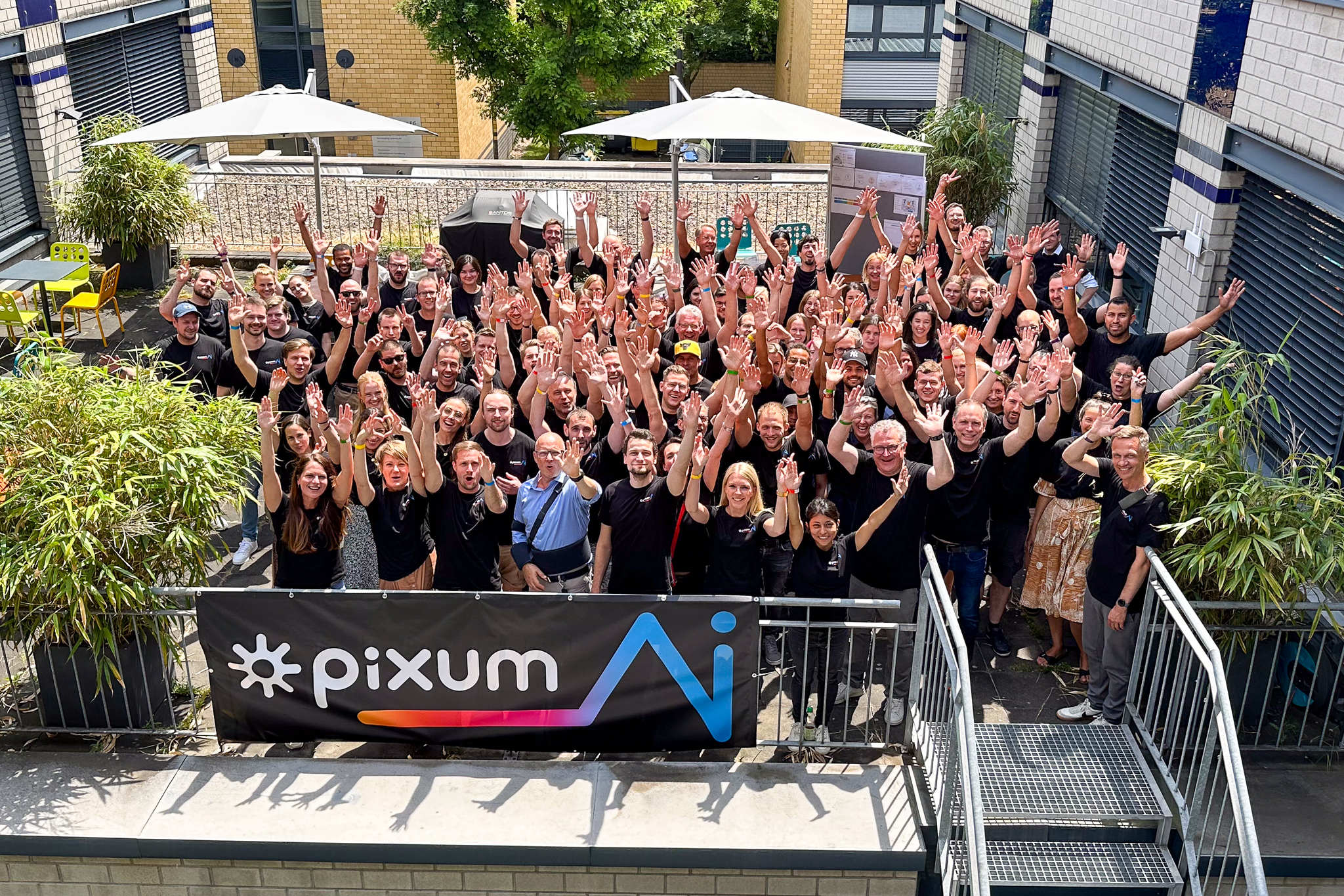 Pixum Mitarbeiter:innen, die jubeln die Hände in die Höhe halten