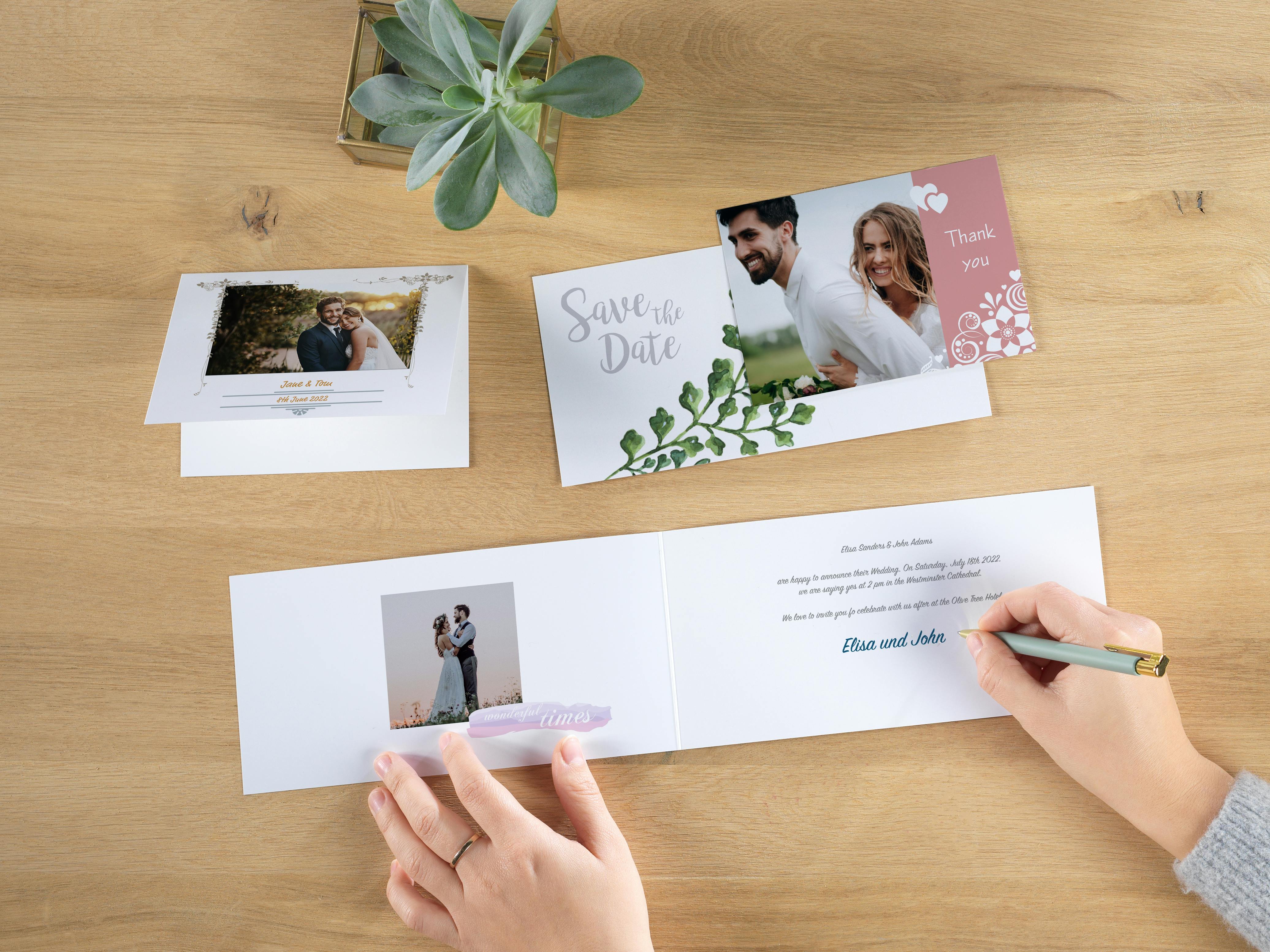Invitaciones de boda personalizadas con una mano que escribe sobre una de ellas