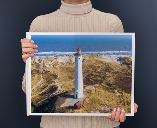 Una donna regge un Fotolibro Pixum XXL panoramico