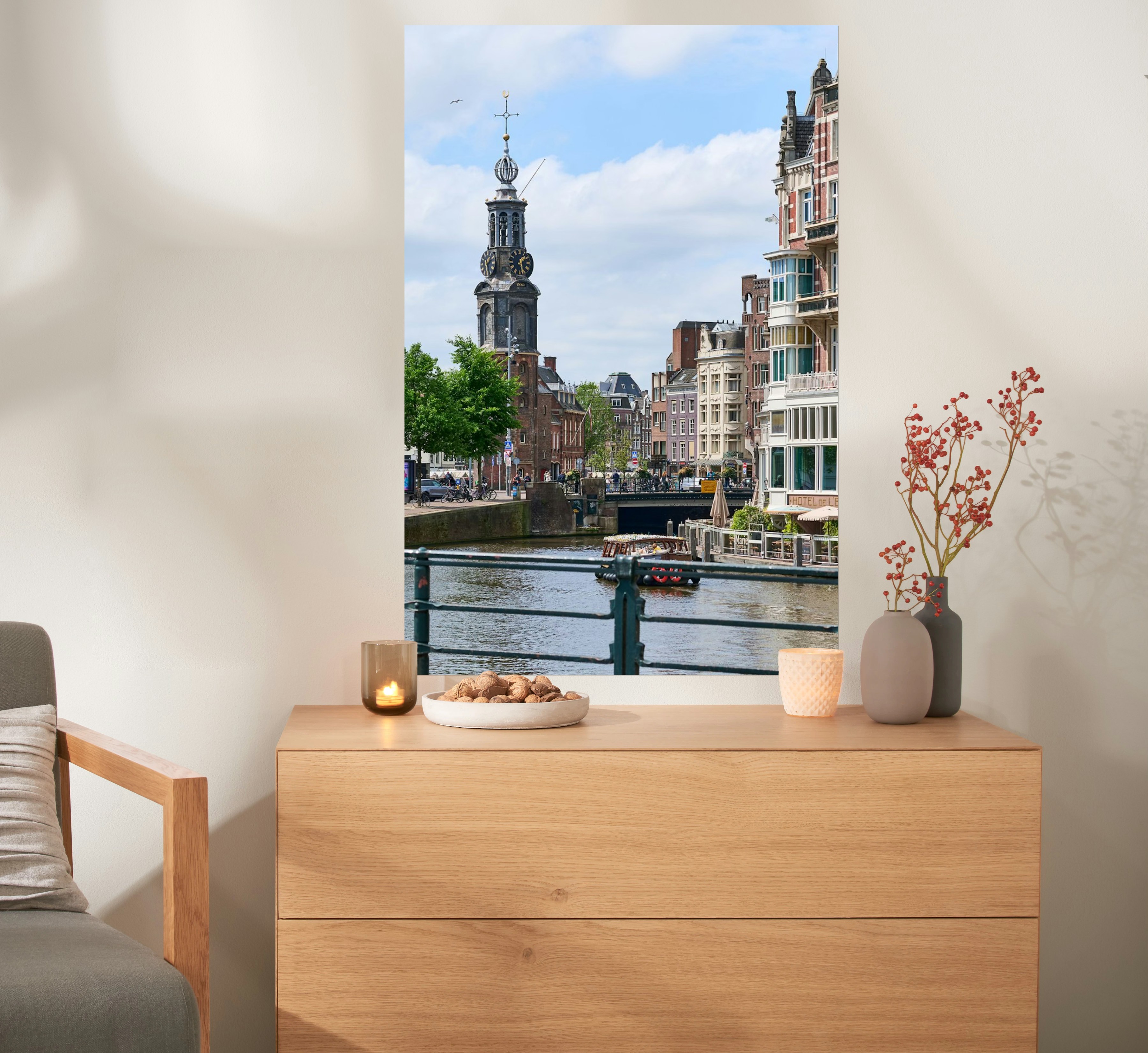 Een fotoposter in het formaat 60x90 met een foto van Amsterdam hangt boven een kast.