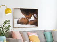 Pixum Fotoleinwand im Schattenfugenrahmen Foto auf Leinwand eingerahmt in einen Schattenfugenrahmen in Schwarz-Gold. Das Foto zeigt ein Baby mit seiner Mutter.