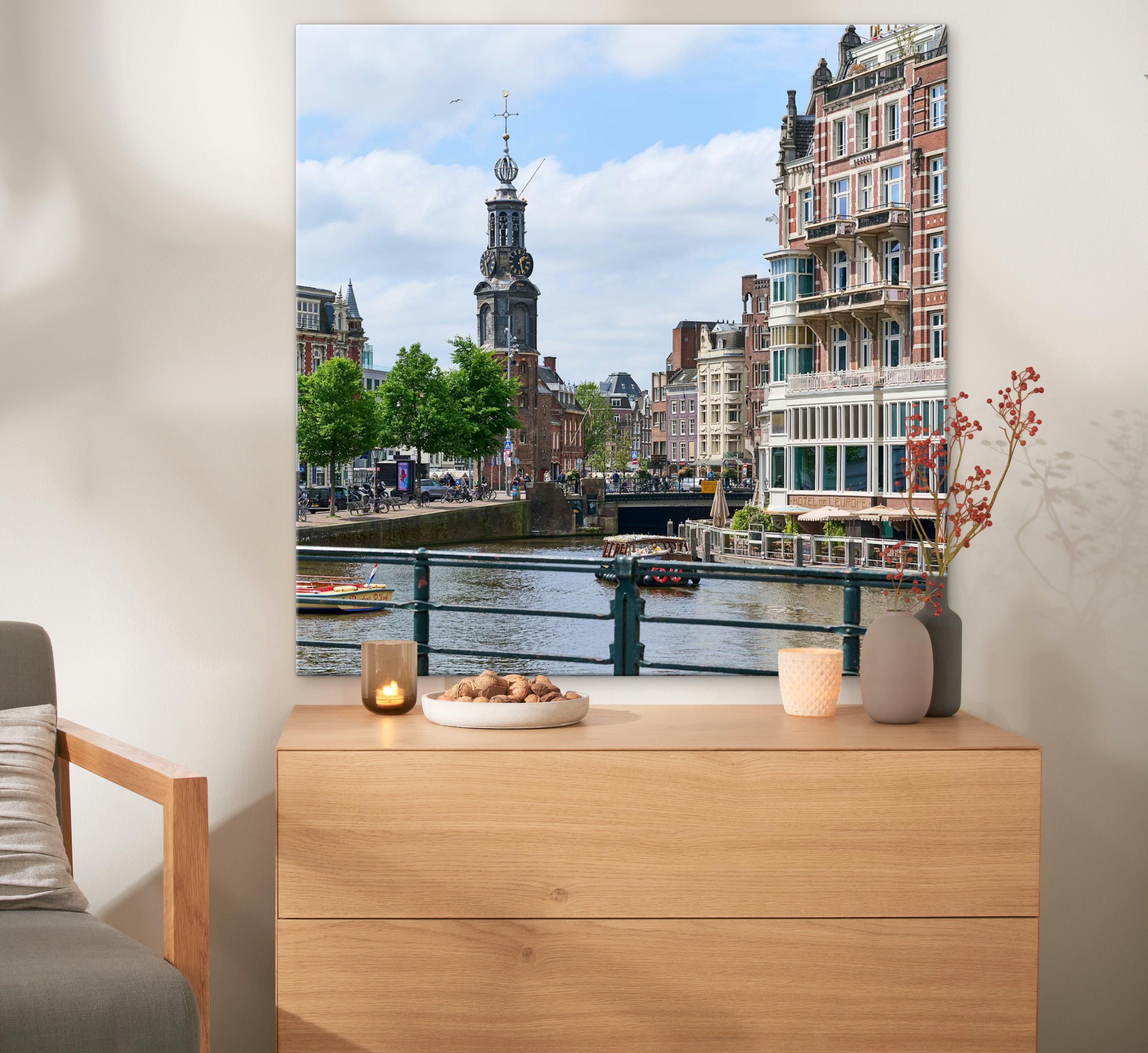 Een canvas in het formaat 100x100 cm met een foto van Amsterdam hangt aan de muur.