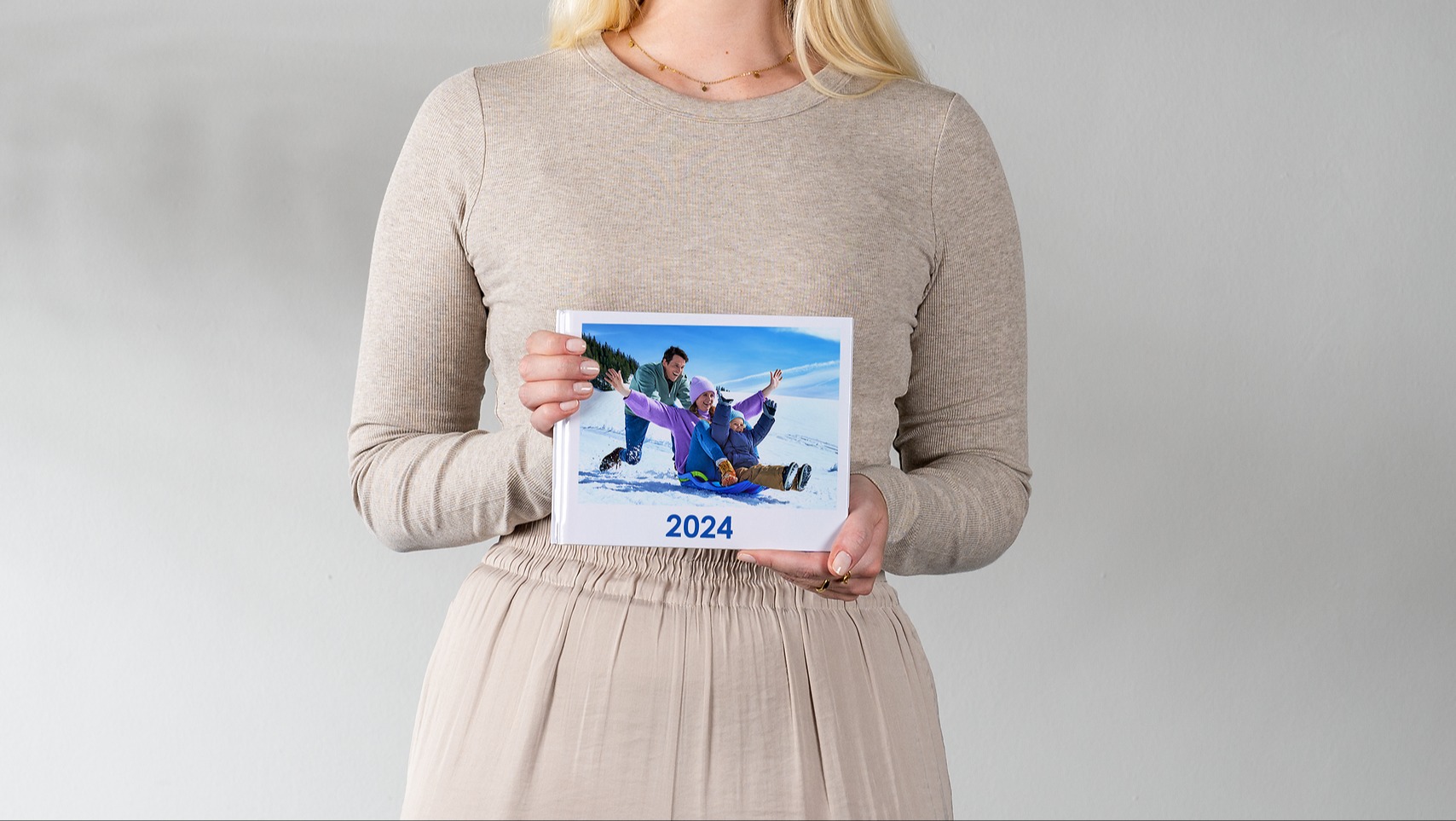 Pixum Fotobuch klein im Querformat mit einem Familienfoto im Schnee und der Jahreszahl 2024