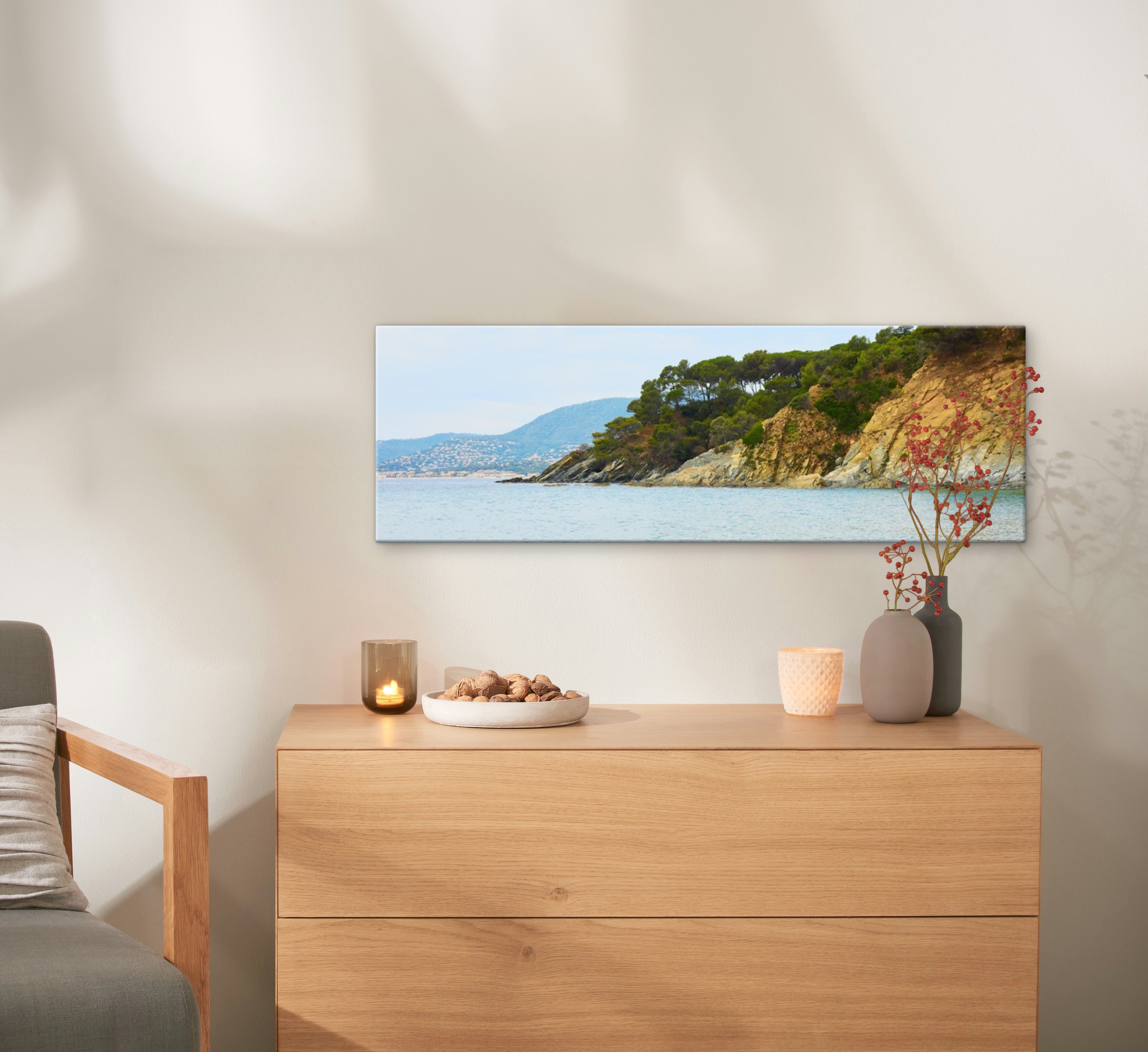 Fotoleinwand mit einem Foto von einem Strand hängt an einer Wand