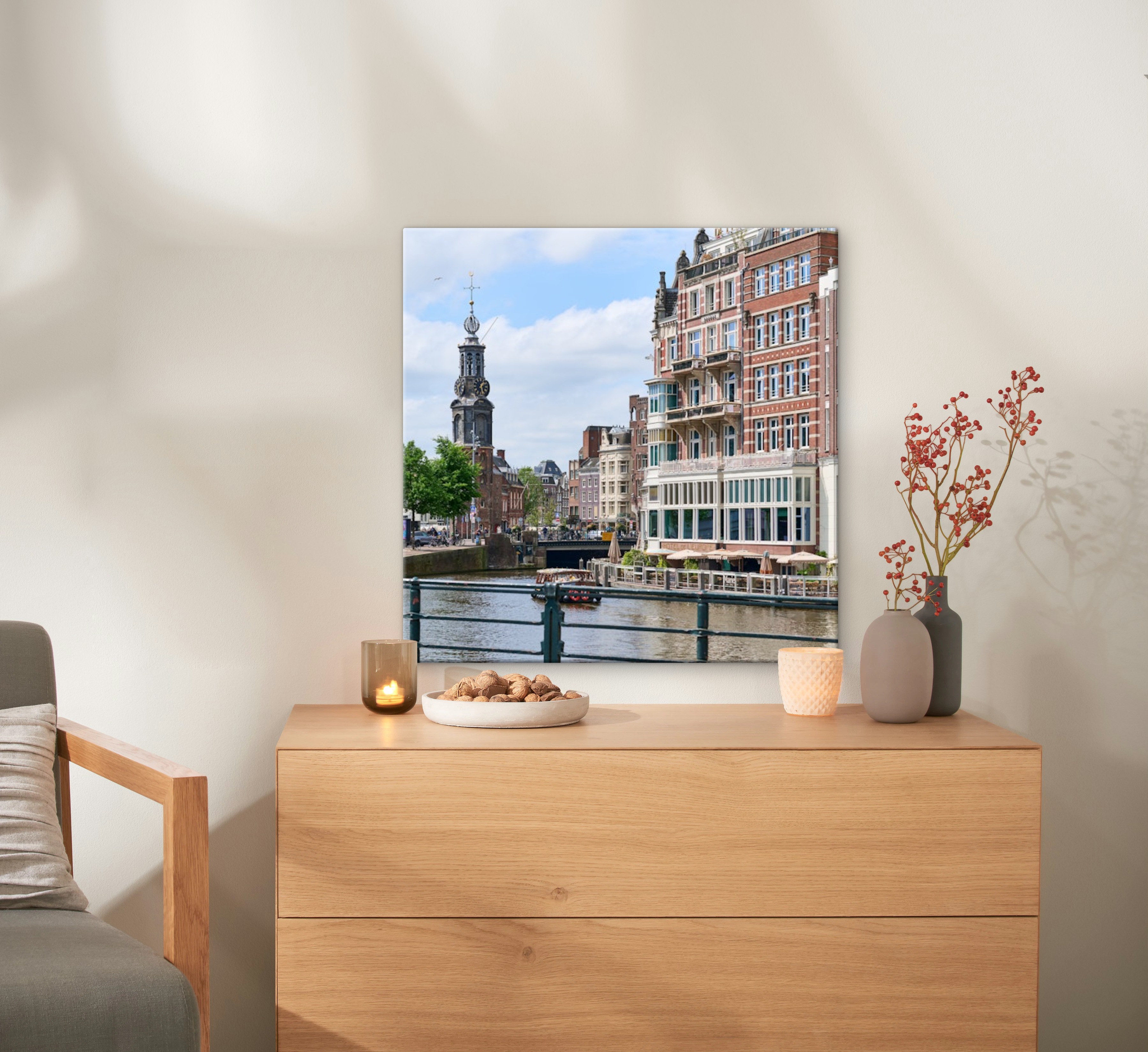 Un lienzo de 60x60 con una foto de Ámsterdam está colgado de una pared arriba de una cómoda