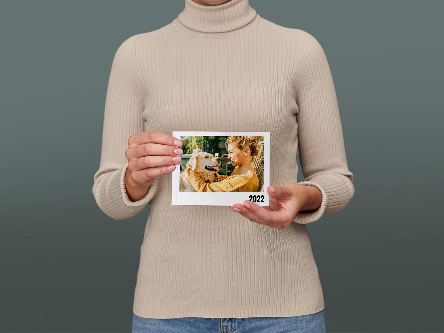 Eine Frau hält ein Pixum Fotobuch mini quer in den Händen
