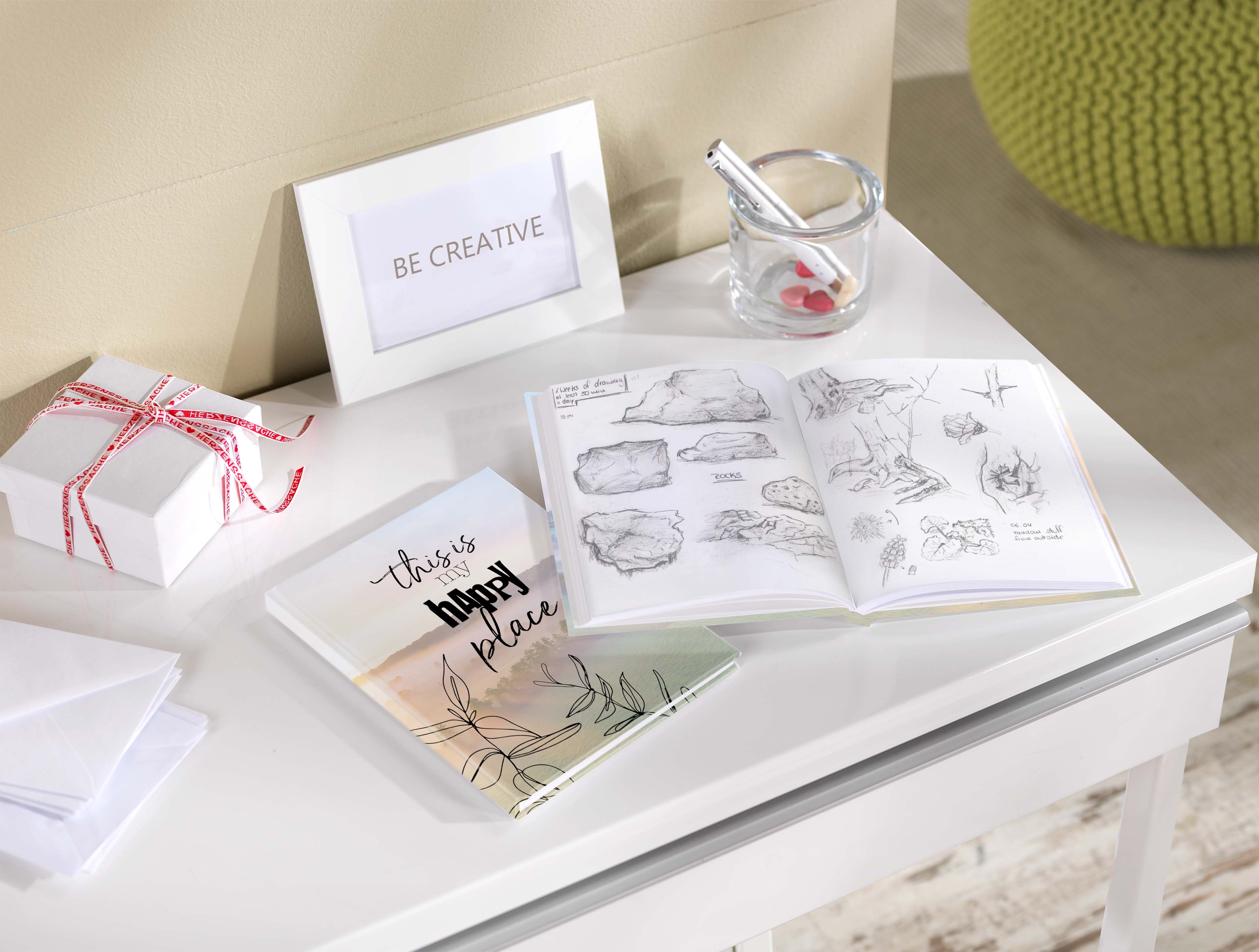 Cuaderno con hojas en blanco con diferentes bocetos sobre una mesa