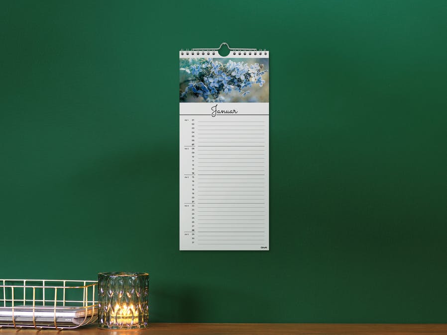 Calendario de cocina pequeño en una pared verde con la foto de una flor