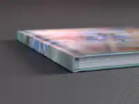 Livre photo Pixum avec couverture rigide Album photo Pixum avec reliure rigide posé sur une surface grise