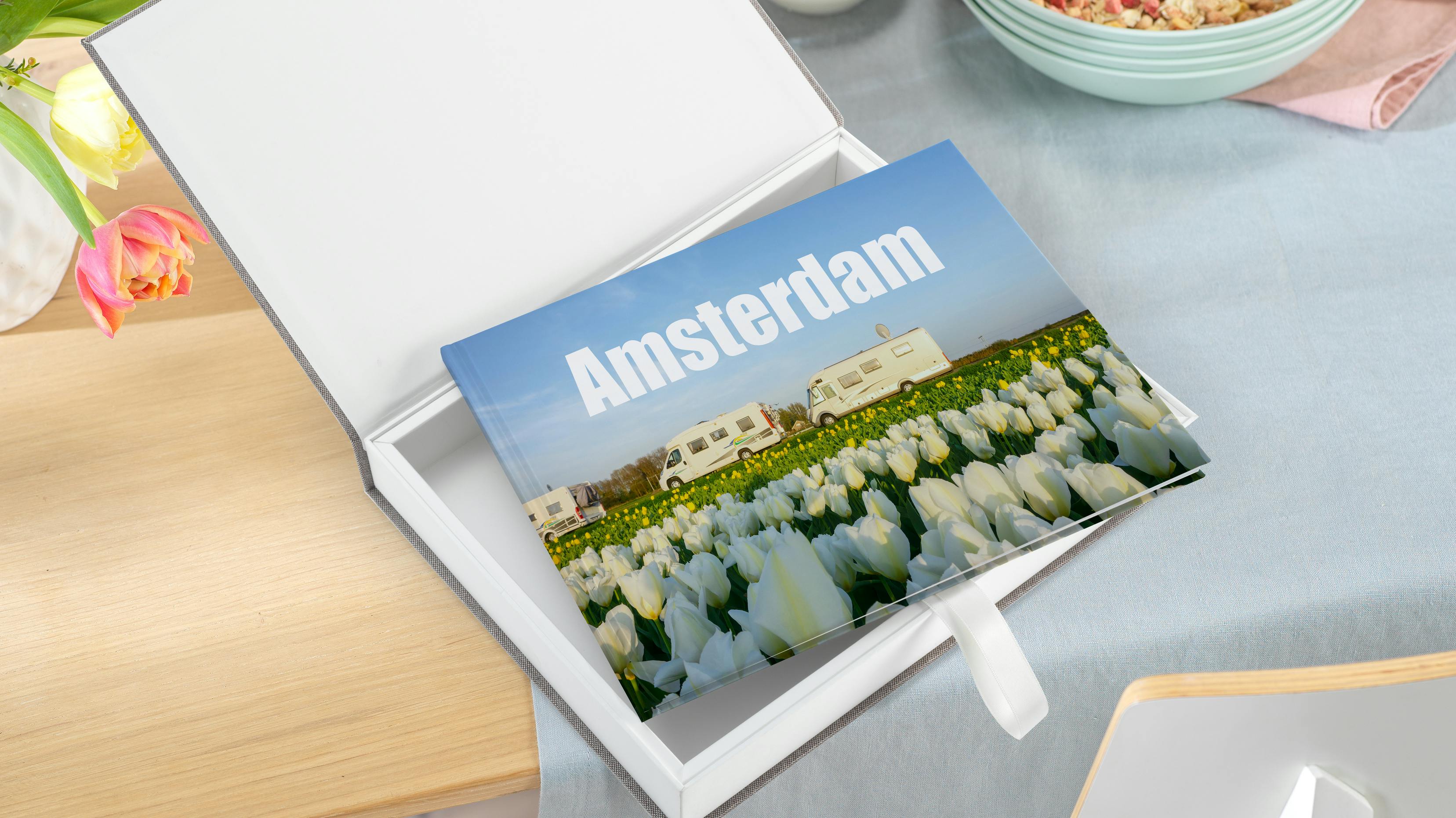Livre photo Pixum avec photos d'un city trip à Amsterdam, emballé dans un coffret cadeau en lin