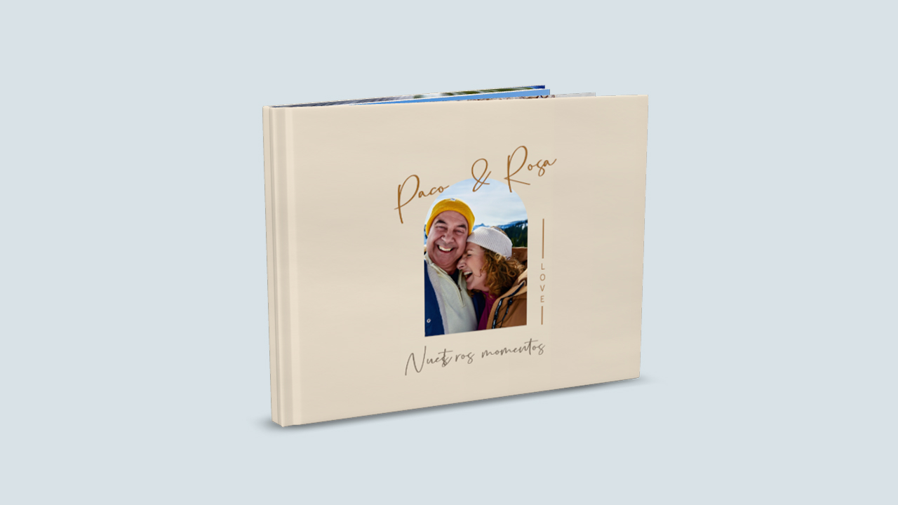 Un álbum de fotos abierto, con una portada diseñada en torno al tema del amor. En el centro aparece la foto de una pareja. Encima figuran los nombres «Paco & Rosa». Debajo de la foto se lee el título «Vuestra historia». El álbum es de color marrón claro.