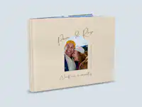 Portada de álbum de fotos con diseño de pareja Un álbum de fotos abierto, con una portada diseñada en torno al tema del amor. En el centro aparece la foto de una pareja. Encima figuran los nombres «Paco & Rosa». Debajo de la foto se lee el título «Vuestra historia». El álbum es de color marrón claro.