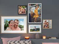 Bild im Holzrahmen Ein Mix aus verschiedenfarbigen Holzrahmen mit Familienbildern und Landschaftsaufnahmen