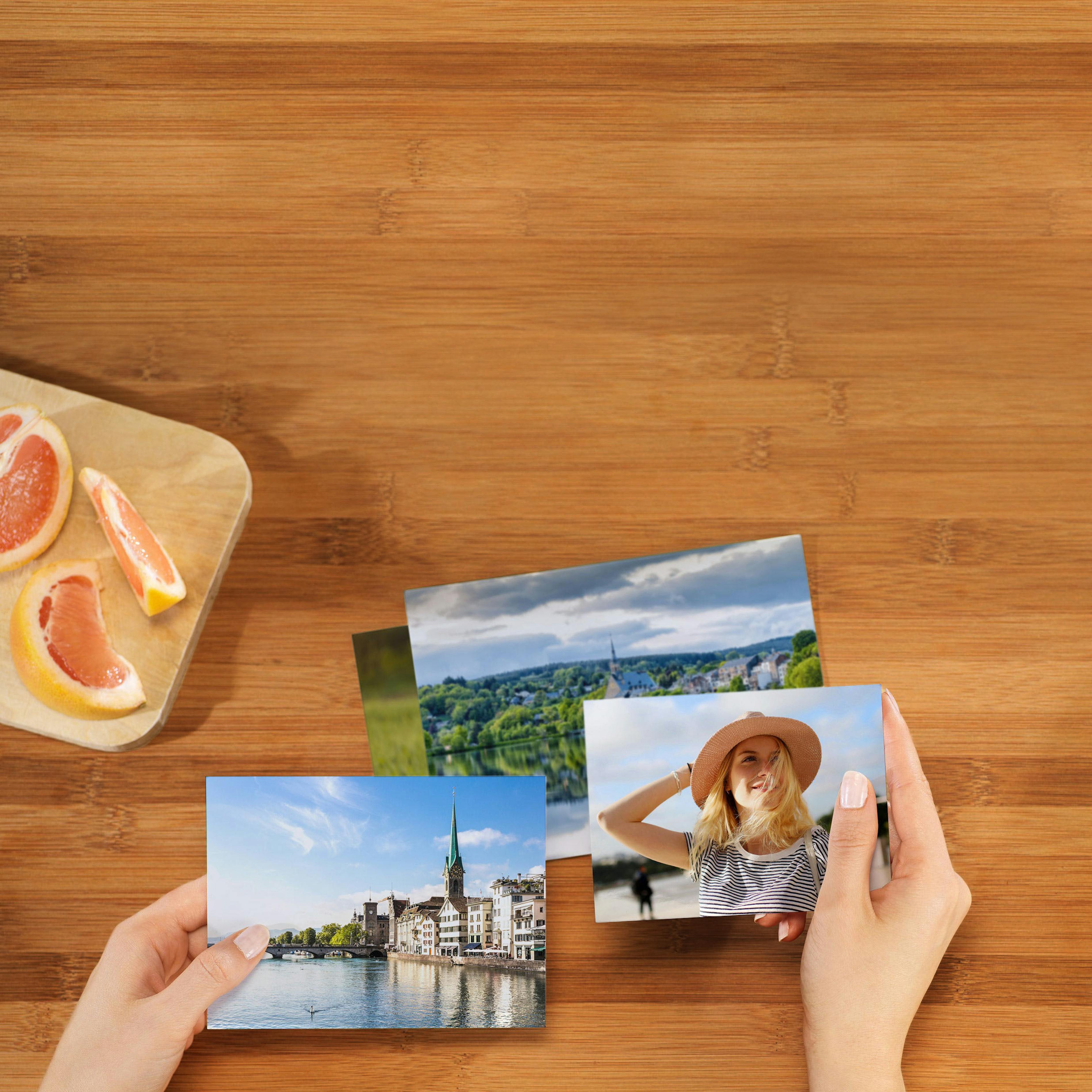 Fotoabzüge entwickeln lassen Hände blättern durch Pixum Fotoabzüge mit Motiven einer Städtereise