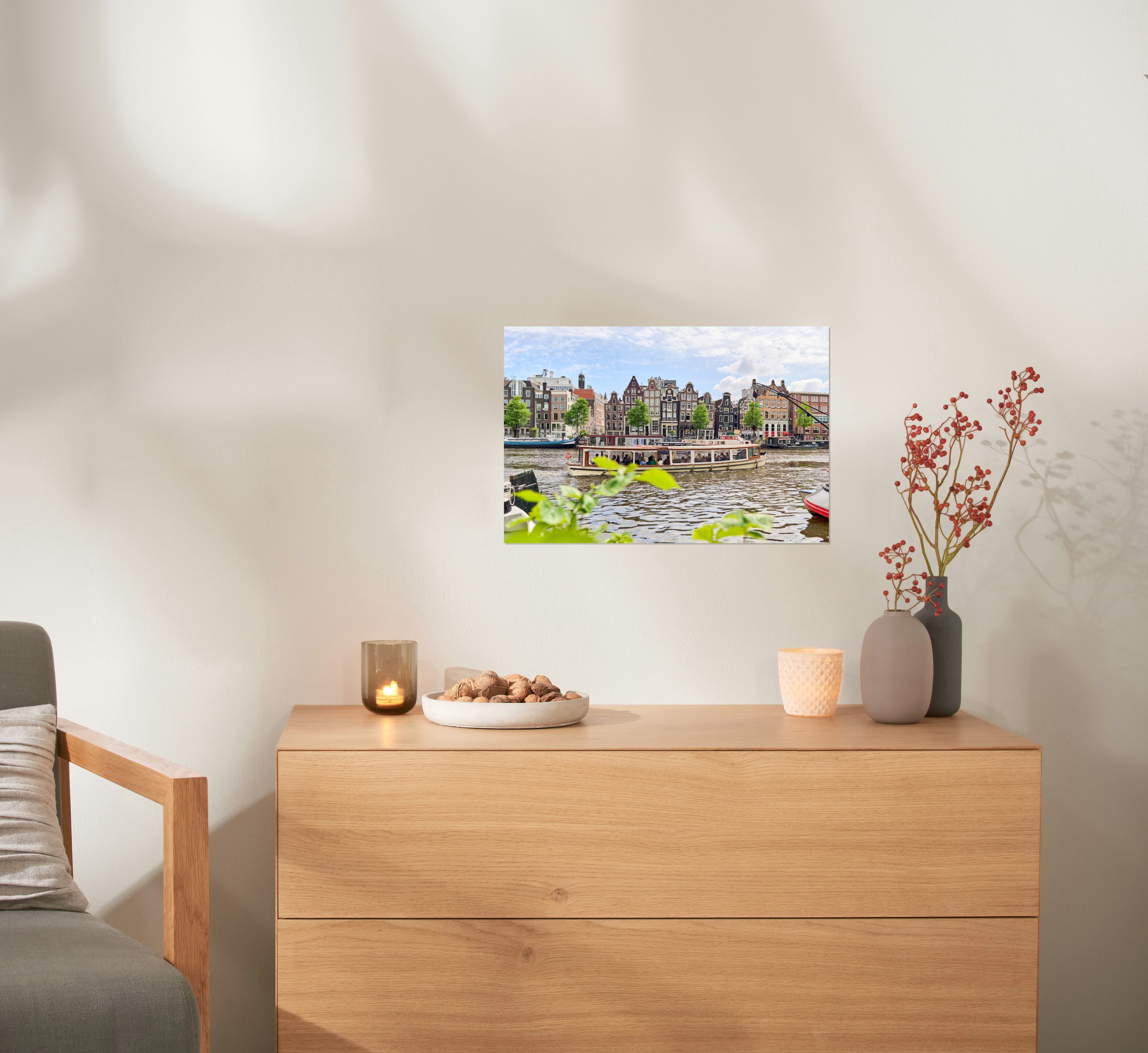 Ein Fotoposter im Format 45x30 cm hängt über einer Kommode und zeigt ein Foto eines Boots in Amsterdam