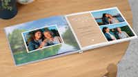 Fotobuch mit Hintergrundbild Ein aufgeklapptes Fotobuch zeigt Bilder von einer Tochter und ihrer Mutter. Auf der einen Seite wurde ein kleiner Text für die Mama eingefügt. Die andere Seite ist mit einem Foto als Hintergrund gestaltet worden.