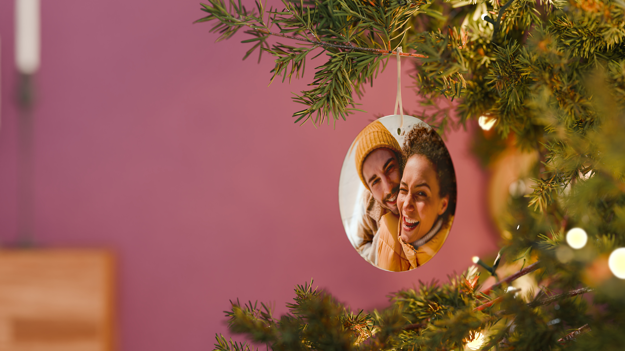 Decorazione di natale con foto di coppia appeso con un nastro all'albero di Natale