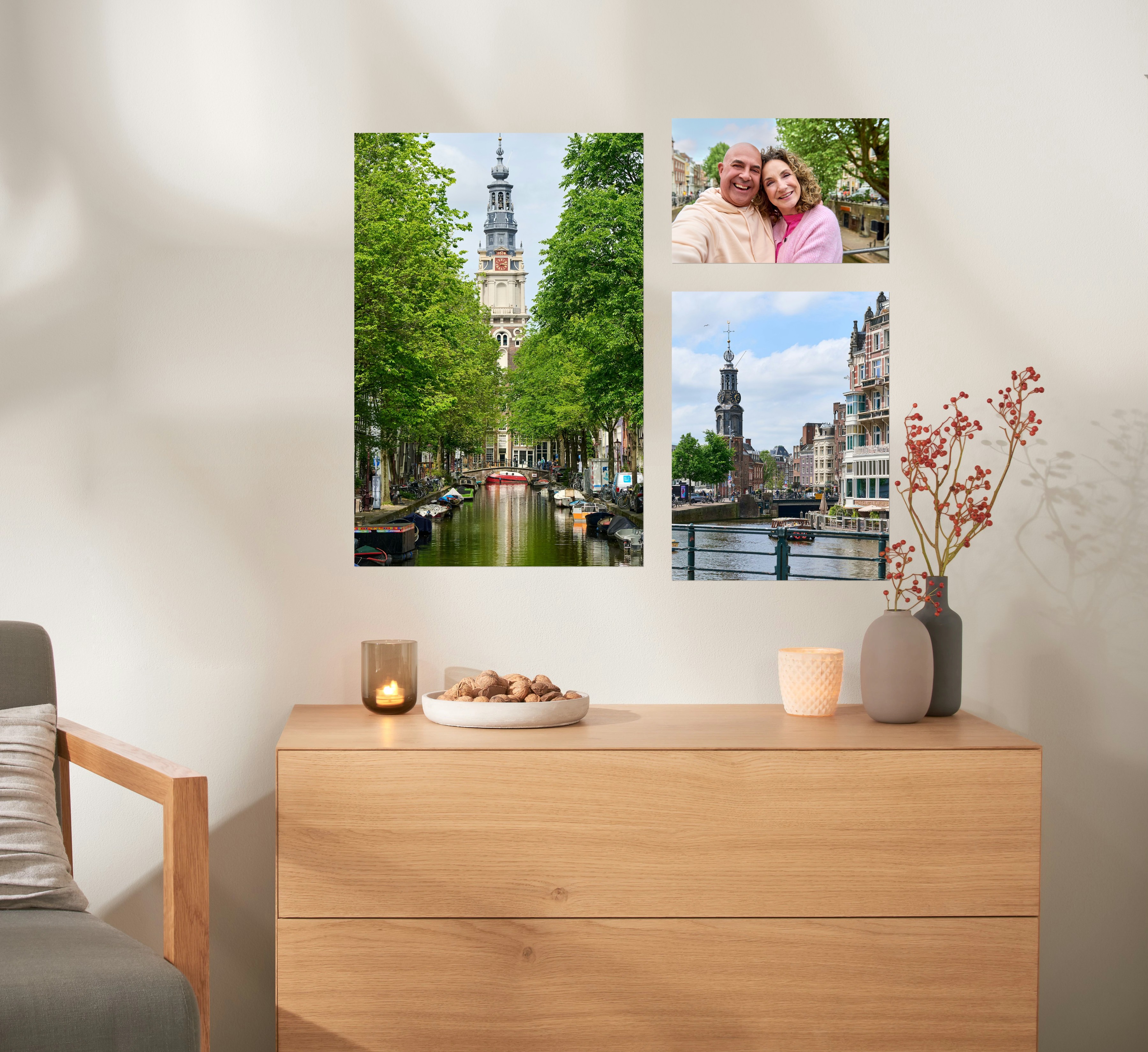 Drie fotoposters in verschillende formaten met foto's van Amsterdam hangen naast elkaar boven een kast.
