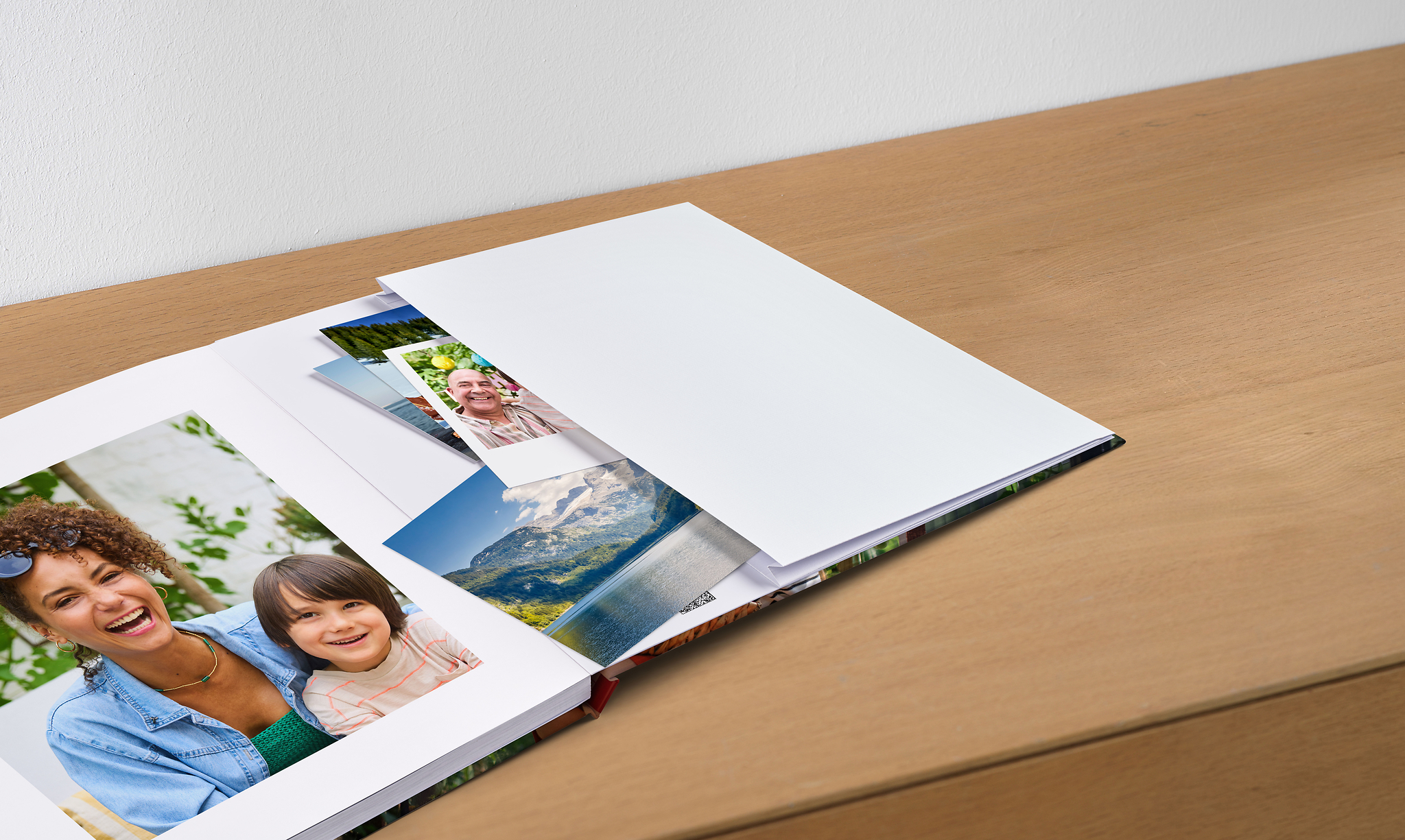 Aufgeschlagenes Pixum Fotobuch mit einer Erinnerungstasche, die Postkarten und Fotos enthält