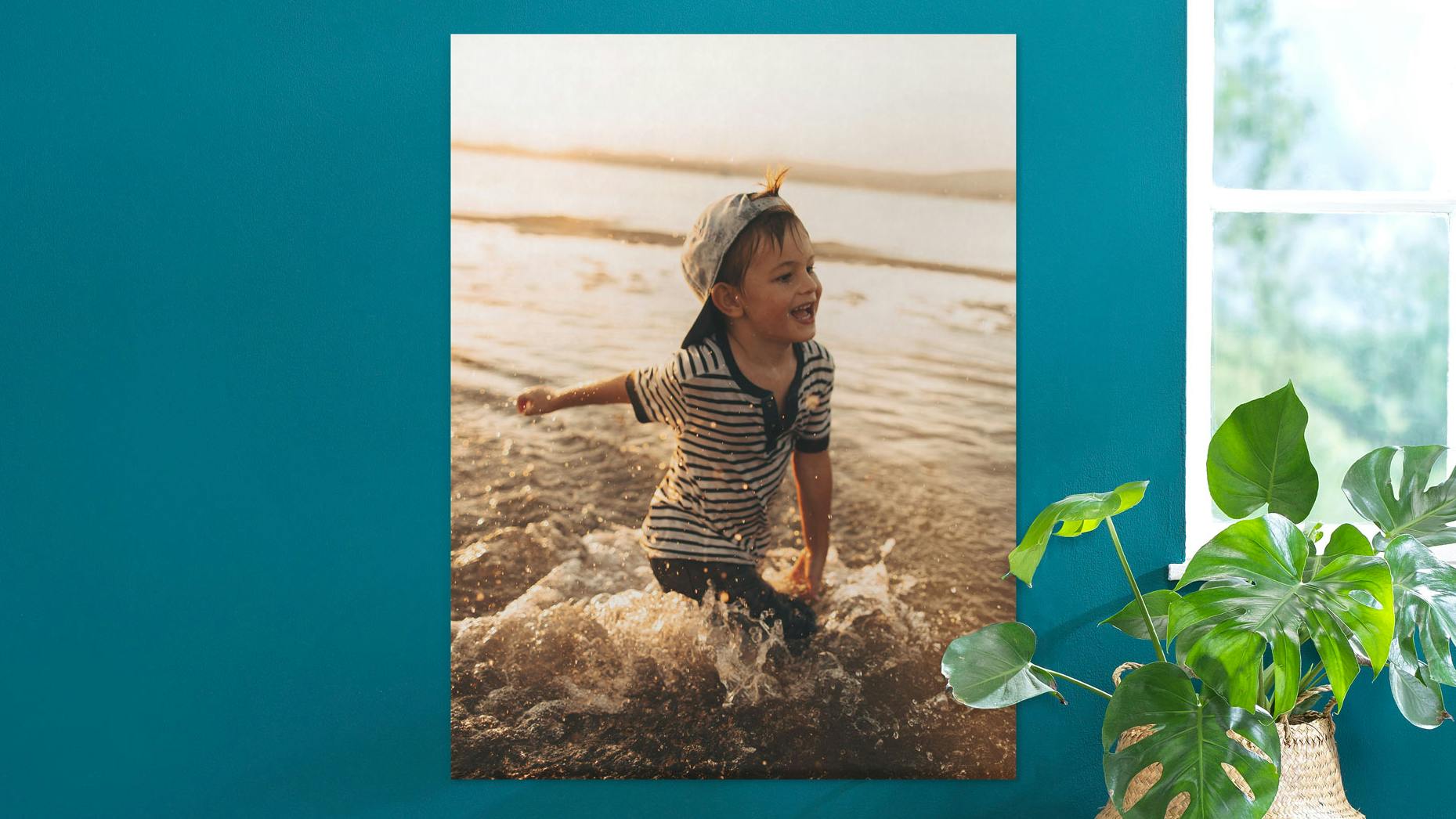 Fotoaffisch i porträttformat med sommarmotiv av en liten pojke i havet