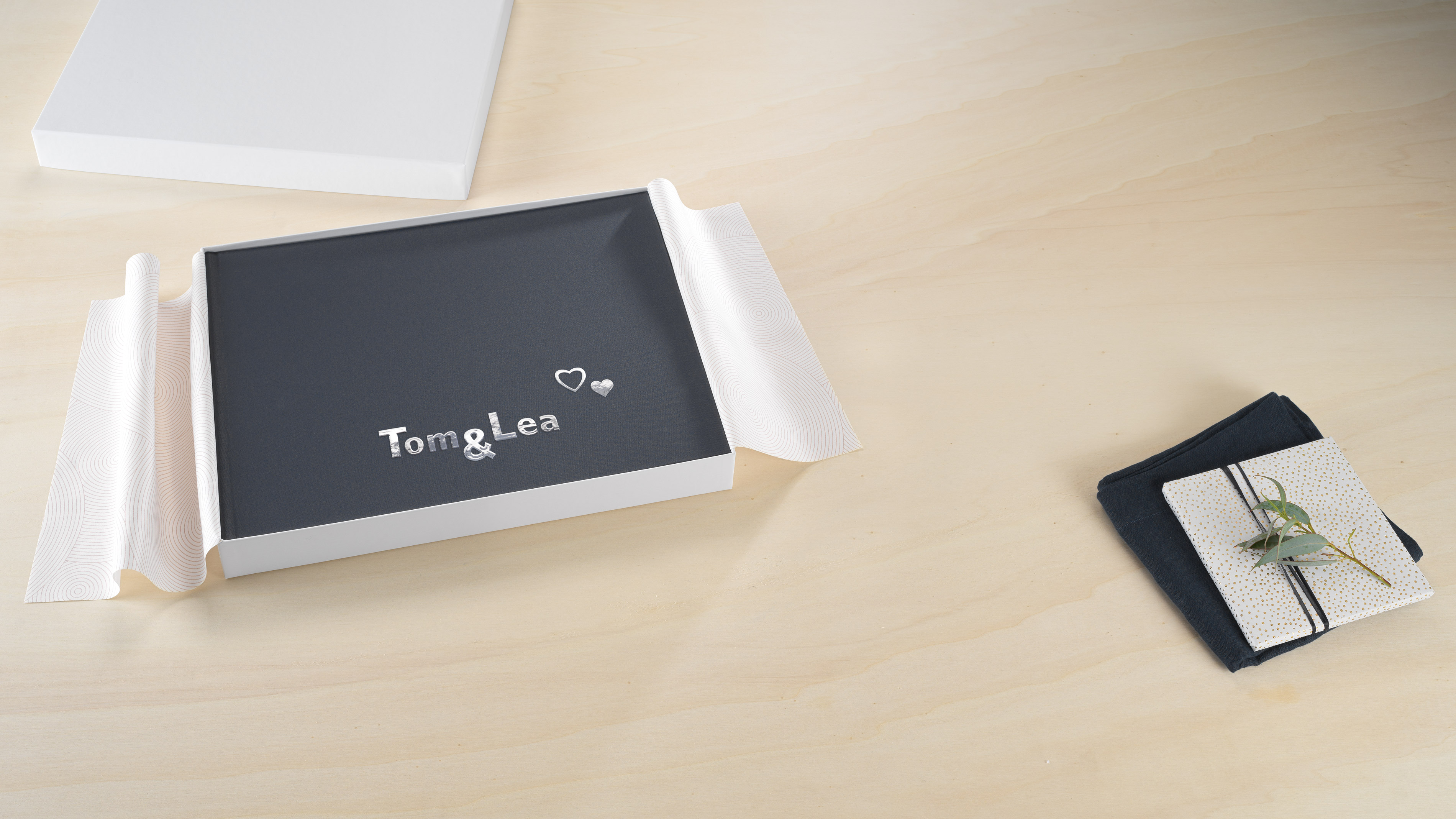 Fotolibro Pixum con copertina in tela grigia in un cofanetto regalo