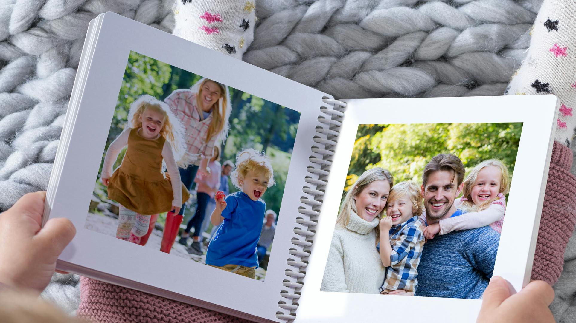Livre photo de bébé avec des photos de famille et tenus dans les mains d'un enfant