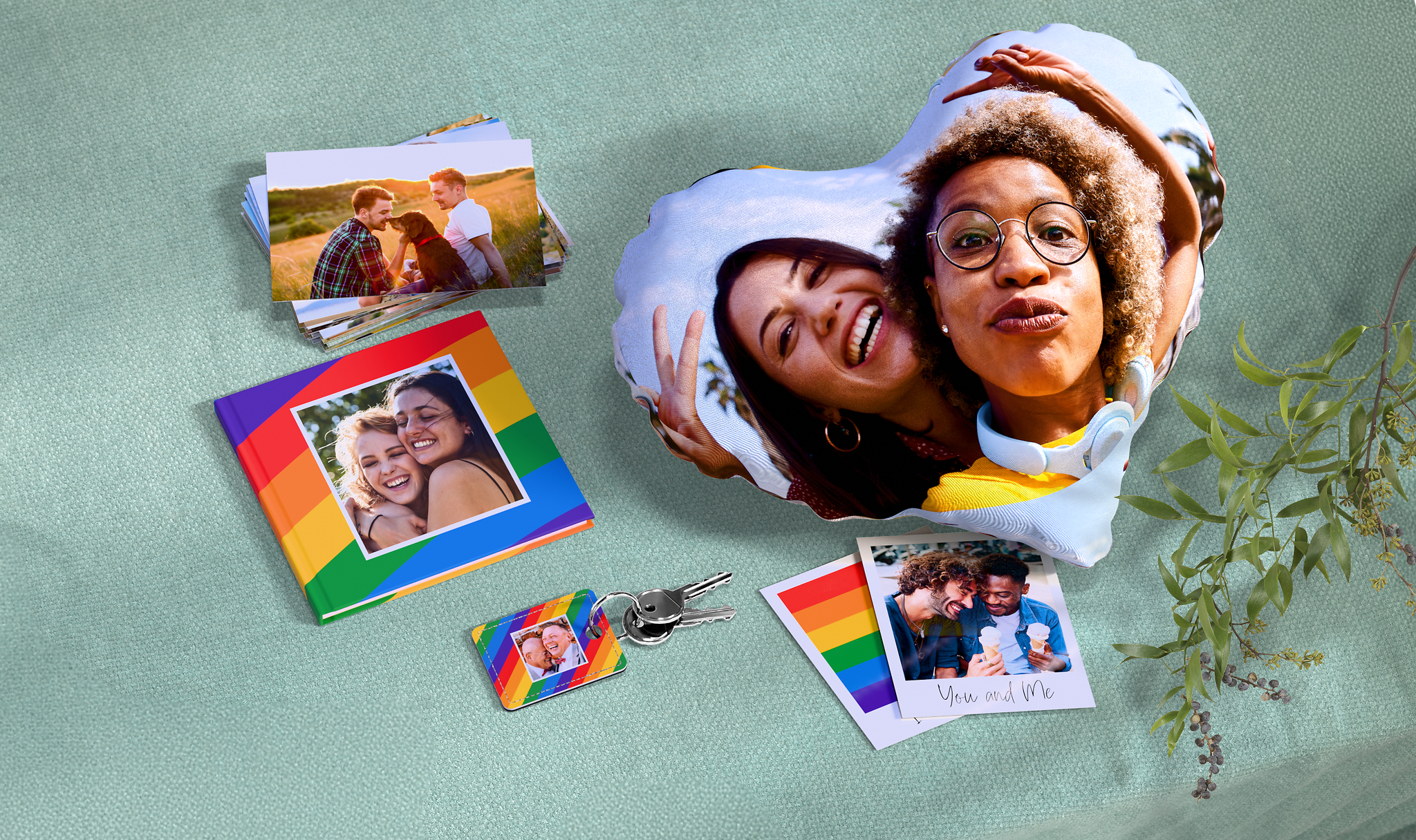 Ein Mix aus Pixum Fotoprodukten (Fotobuch, Fotoabzüge, Fotokissen, Foto-Schlüsselanhänger) mit dem Regenbogen-Pride-Design. 