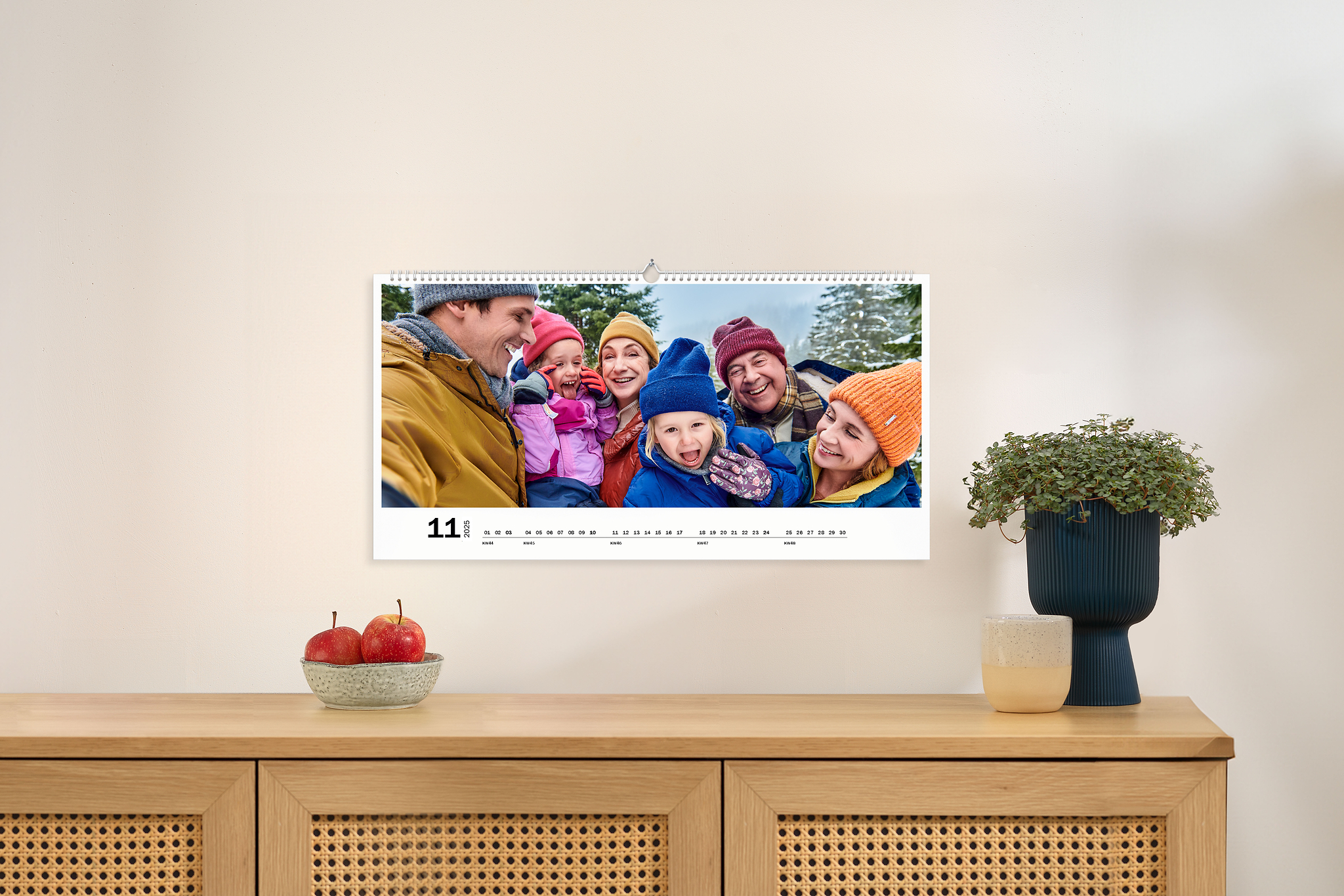 Panoramakalender XXL mit einem Familienbild an einer Wand 