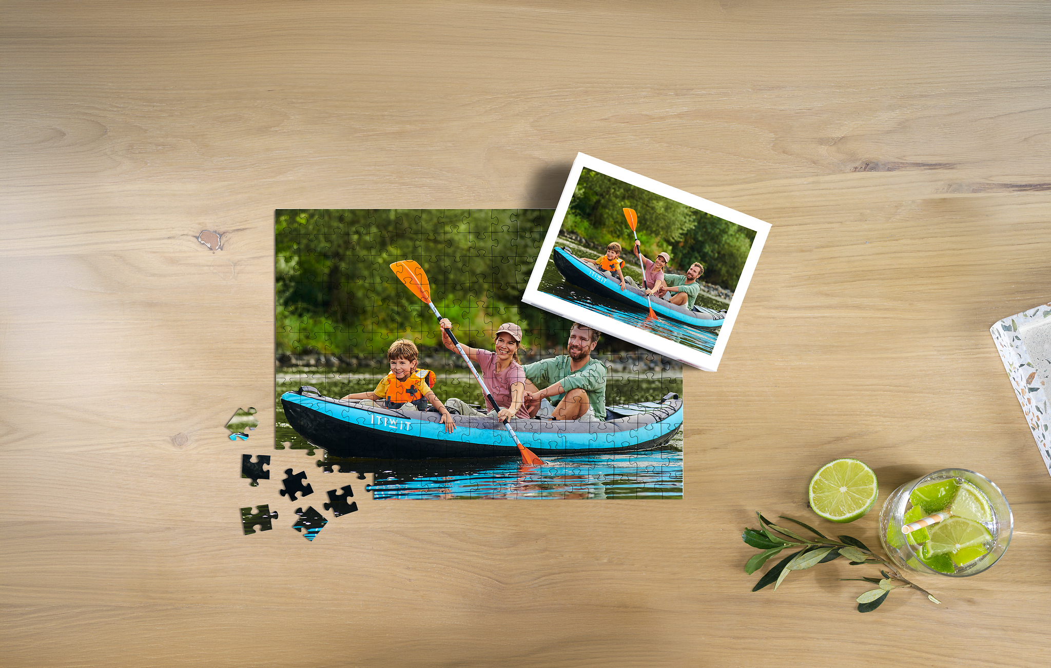 Fotopuzzle mit 200 Teilen und einem Bild von einer Familie beim Kanu fahren, aufliegend auf einem Tisch, inklusive einer Box für das Puzzle