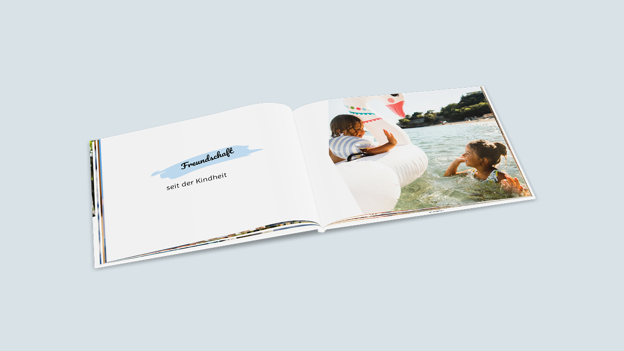 Aufgeschlagenes Fotobuch mit einem Kindheitsfoto von zwei Freund:innen auf der rechten Seite und dem Text "Freunde seit der Kindheit" auf der linken Seite.
