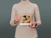 Eine Frau hält ein Pixum Fotobuch klein quadratisch in den Händen