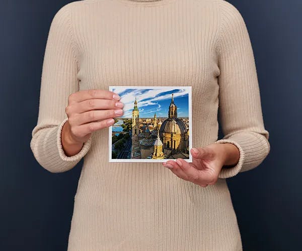 Una mujer sostiene un Álbum Digital Pixum pequeño cuadrado