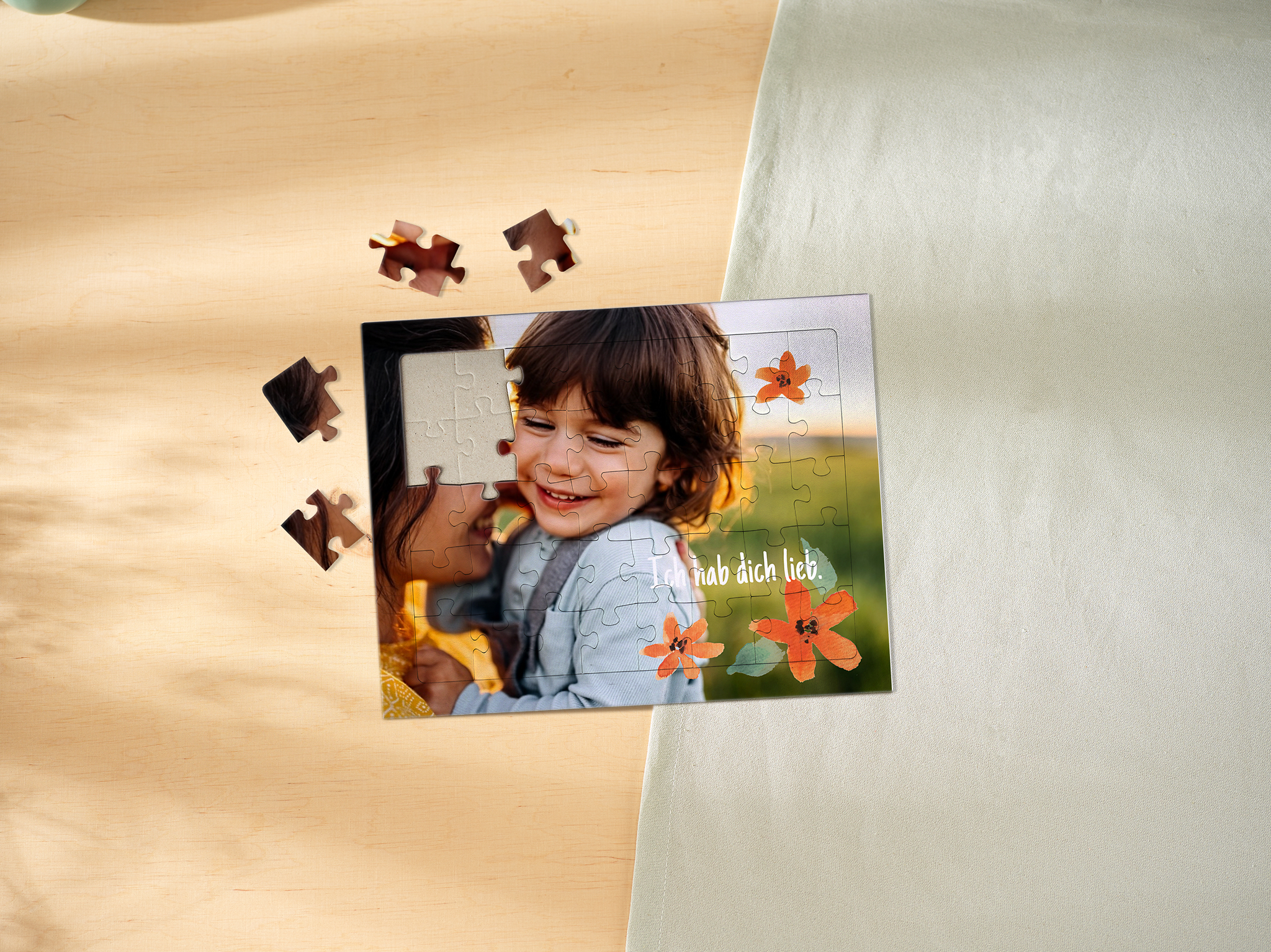 Fotopuzzle für Kinder mit Rahmen. Das Motiv zeigt eine Mutter, die ihr Kind im Arm hält, dekoriert mit Schriftzug und Cliparts. 