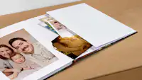 Babyfotobuch mit Erinnerungstasche Fotobuch mit einer integrierten Erinnerungstasche auf der letzten Seite, in die lose Fotos oder Andenken gesteckt werden können.