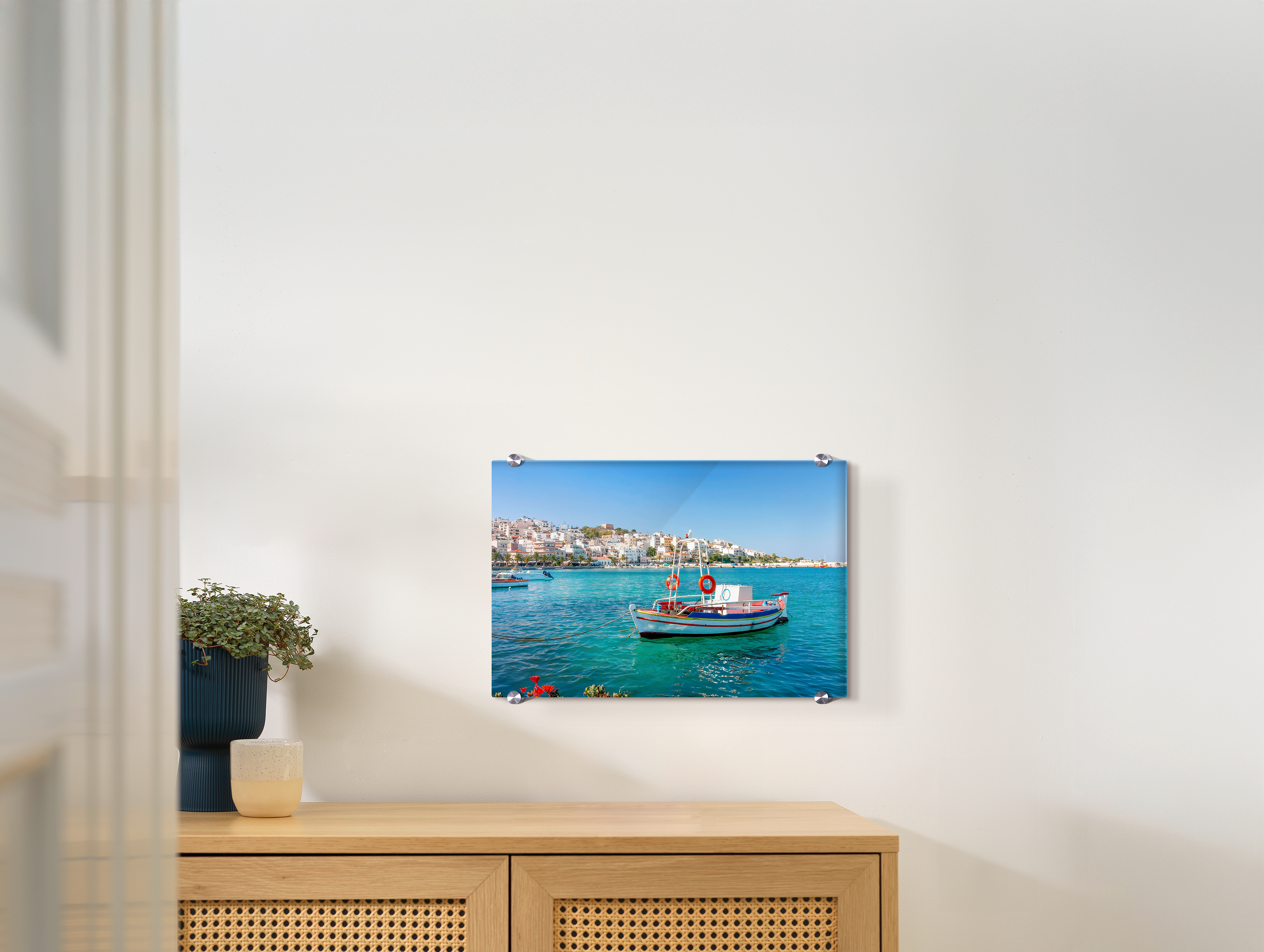 Ein Wandbild aus Acrylglas hängt an einer Wand. Darauf ist ein Urlaubsmotiv abgebildet.