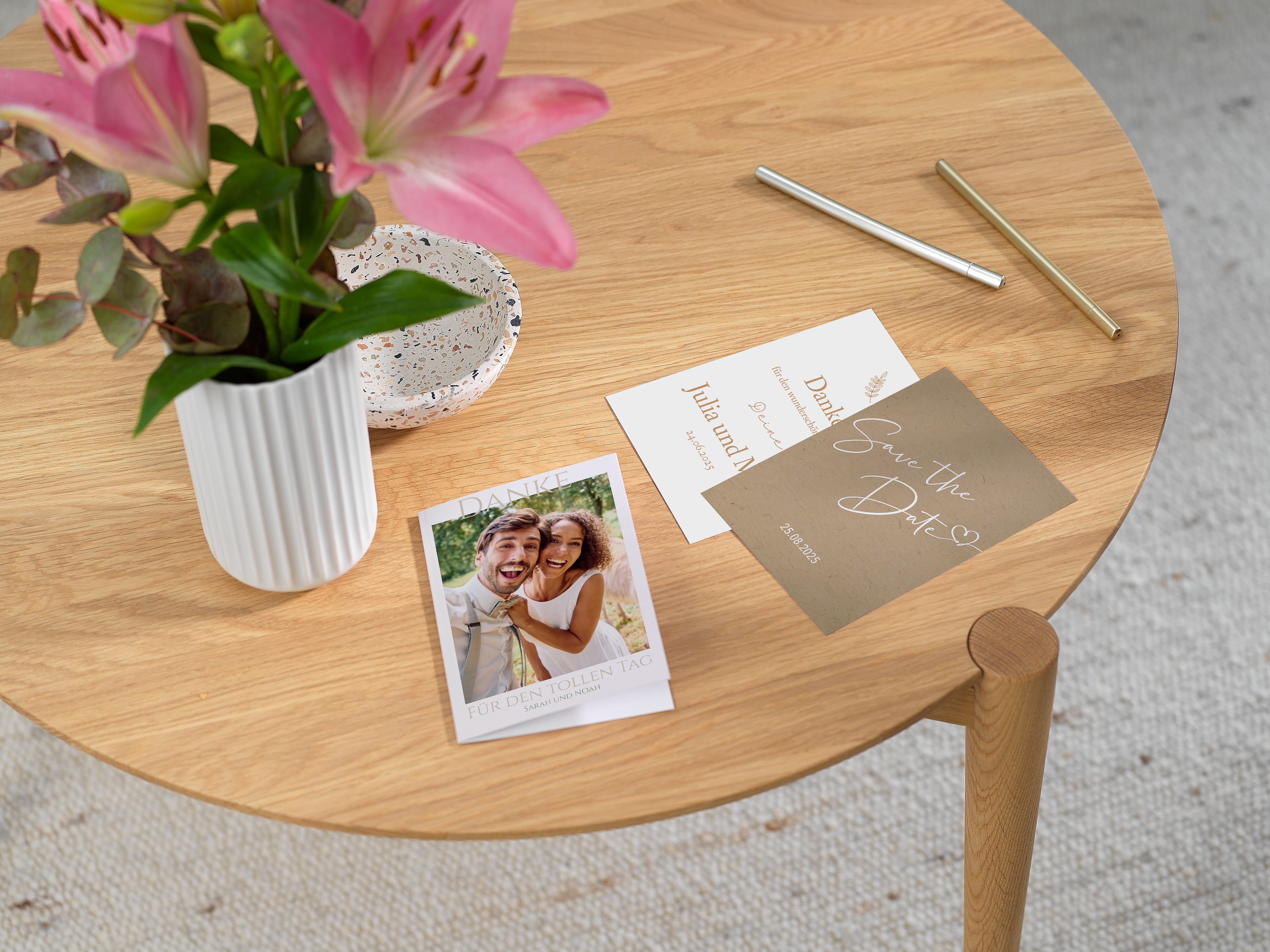 Fotogrußkarten zum Anlass Hochzeit legen nebeneinander auf einem Tisch. Hochzeitsfotos und Dankestexte sind auf die Karten gedruckt