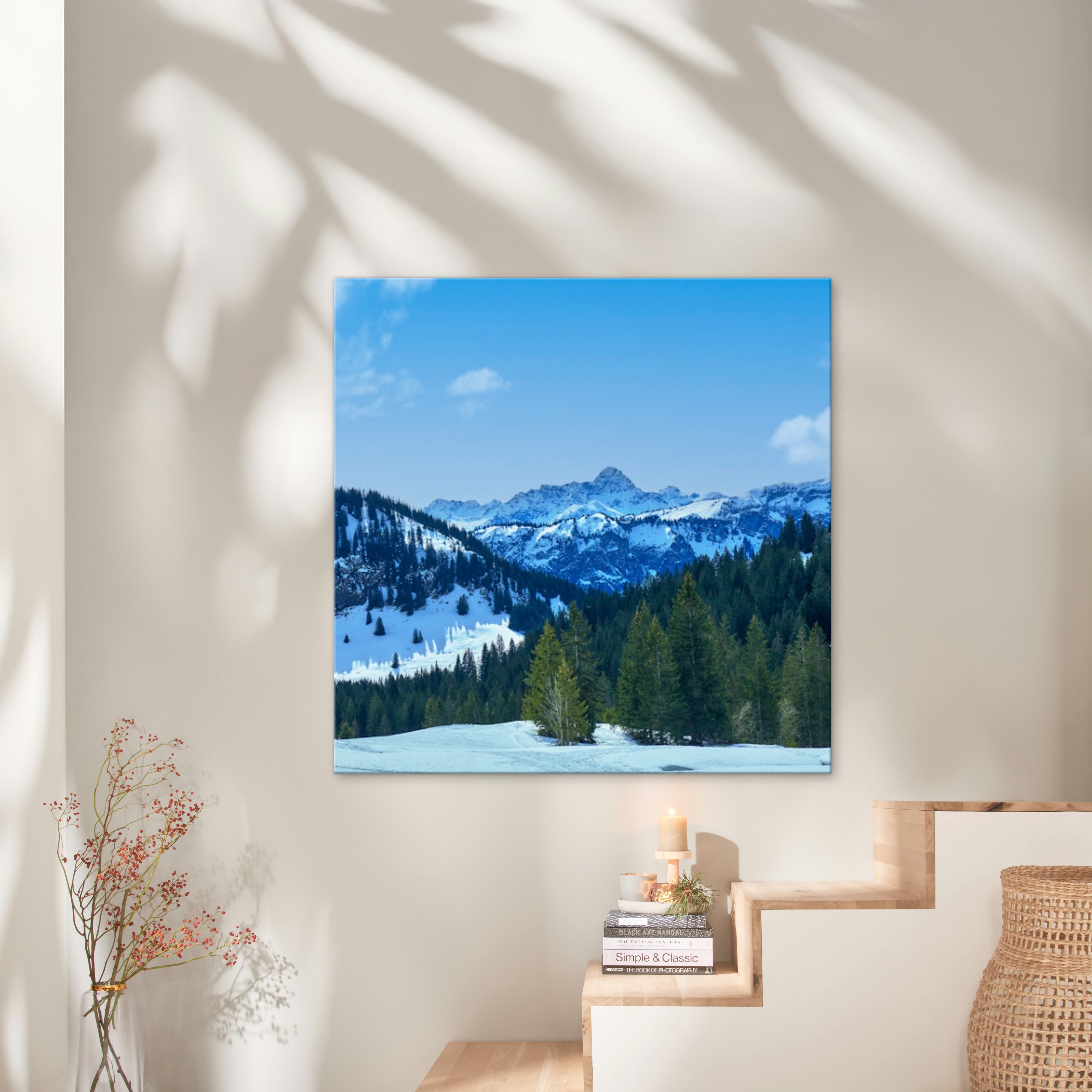 Eine Fotoleinwand im Format 100x100 cm hängt an einer Wand und zeigt eine bergige Winter