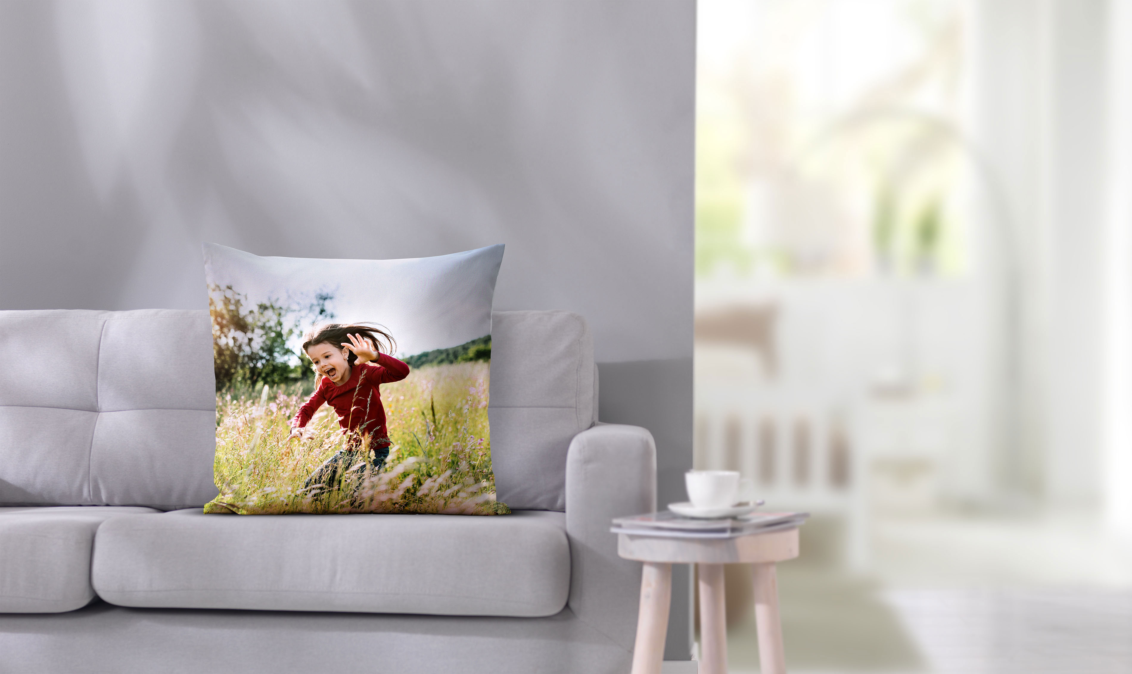 Fotokissen 80x80 mit fröhlichem Kindermotiv auf einem Sofa.