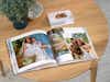 Fotobuch und Fotogrußkarte mit Hochzeitsbildern auf einem Tisch