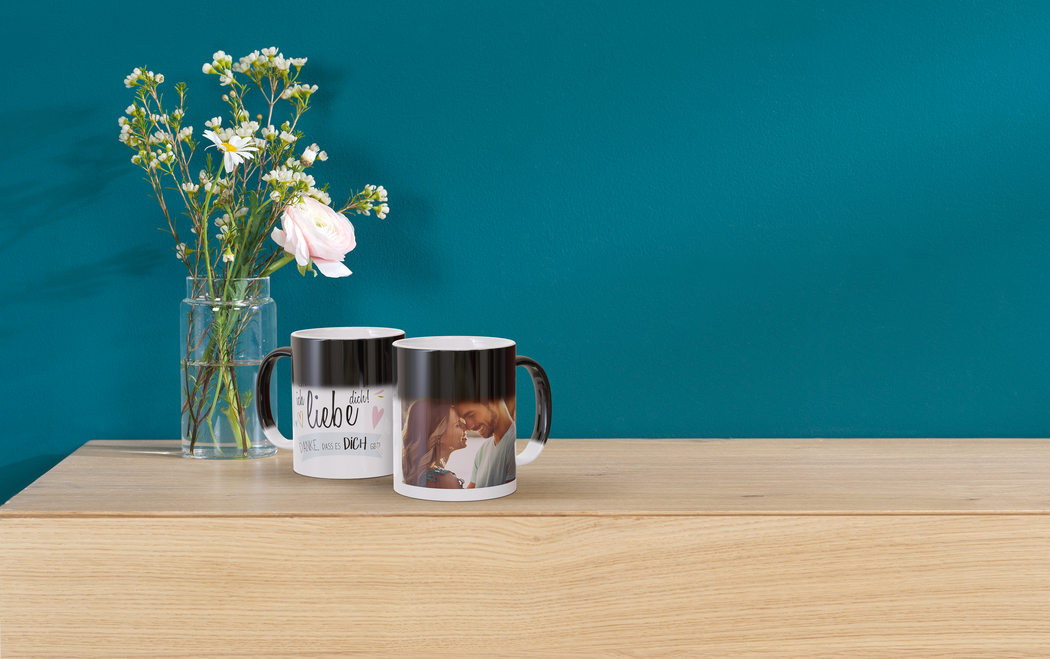 Zwei Zauber-Fototassen mi einem Design zum Thema Liebe und einem Foto eines verliebten Pärchens.