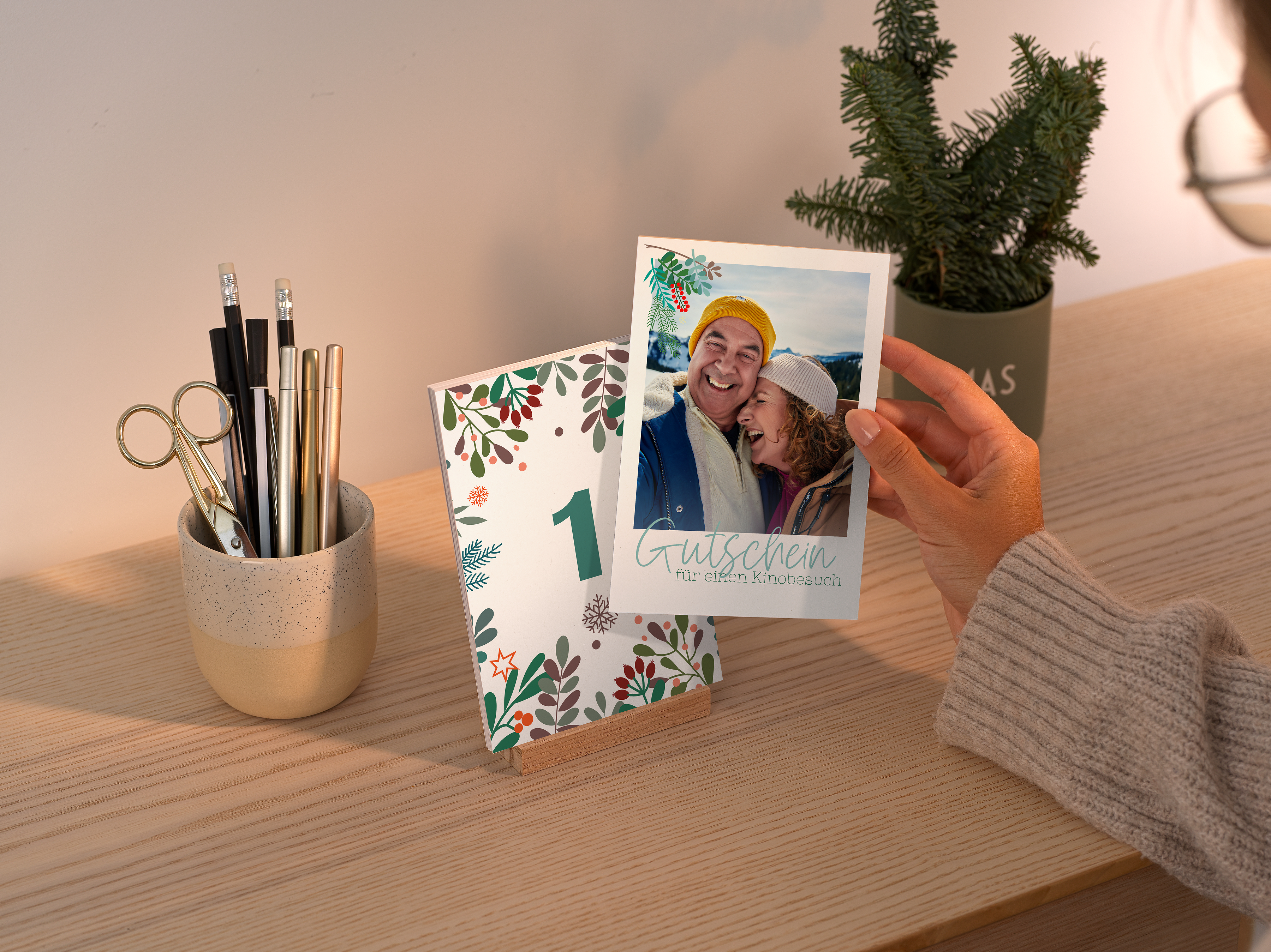 Pixum Tisch-Adventskalender auf einer Kommode mit Pärchenfotos und einem Gutschein