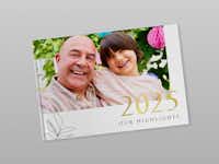 Fotoboek voor een grijze achtergrond met de titel "2025 - OUR HIGHLIGHTS" Gesloten fotoboek van Pixum voor een grijze achtergrond. Op het boek is een foto van een man en een jongen. Het fotoboek is een jaarboek met de titel "2025 our highlights" en een bloementekening.