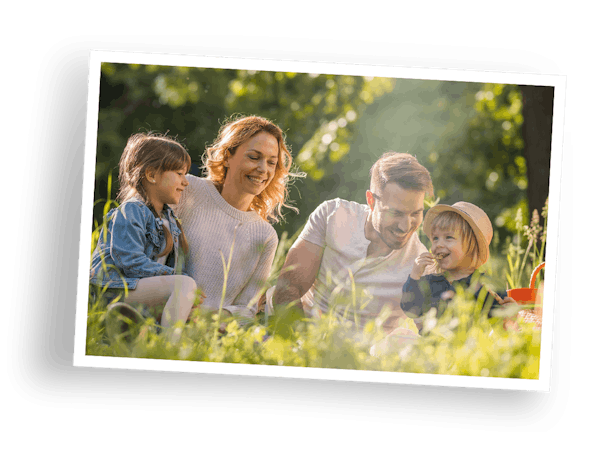 Vrijstaand beeld van een fotoafdruk met een witte rand en een familie in het gras