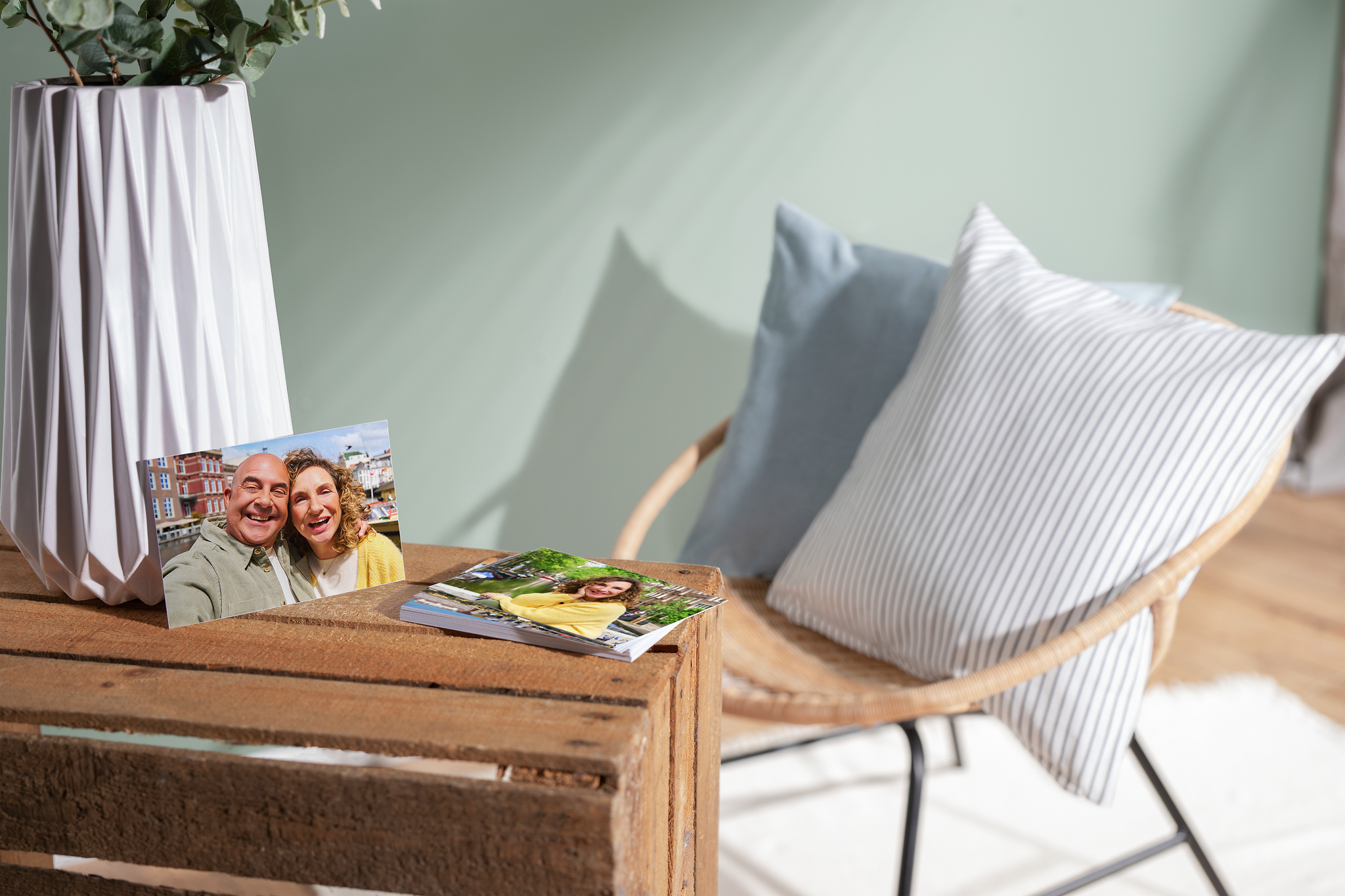 Fotoabzüge aus 100% recyceltem Material mit Fotos von einem Ehepaar aufliegend auf einer Holzkiste