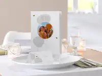 Tafel- en menukaarten bestellen Menukaart met foto voor een bruiloft staat op een tafel.